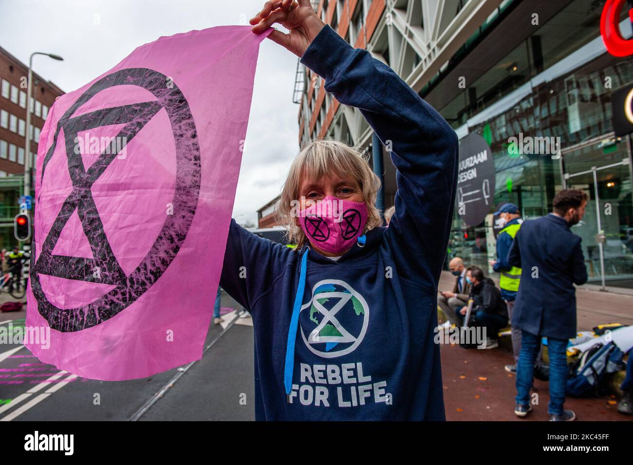 November 17., Den Haag. Mehrere Extinction Rebellion-Aktivisten und mit Hilfe der Dramatikerin Maria Goos und der niederländischen Schauspieler Sieger Sloot und Michiel de Jongdemand führten eine disruptive Aktion außerhalb des Gebäudes des Wirtschaftsministeriums und der Klimapolitik durch. Die Aktivisten fordern, dass die Subventionen für fossile Brennstoffe sofort gestoppt werden und die Gruppe fordert zudem die sofortige Freigabe der sogenannten Shell Papers. Während der Aktion versuchten die Aktivisten, das Gebäude zu erreichen, aber sie konnten das Gebäude wegen der hohen Polizeipräsenz nicht erreichen. Die Aktivisten beenden die Blockierung des Verkehrs, in Stockfoto