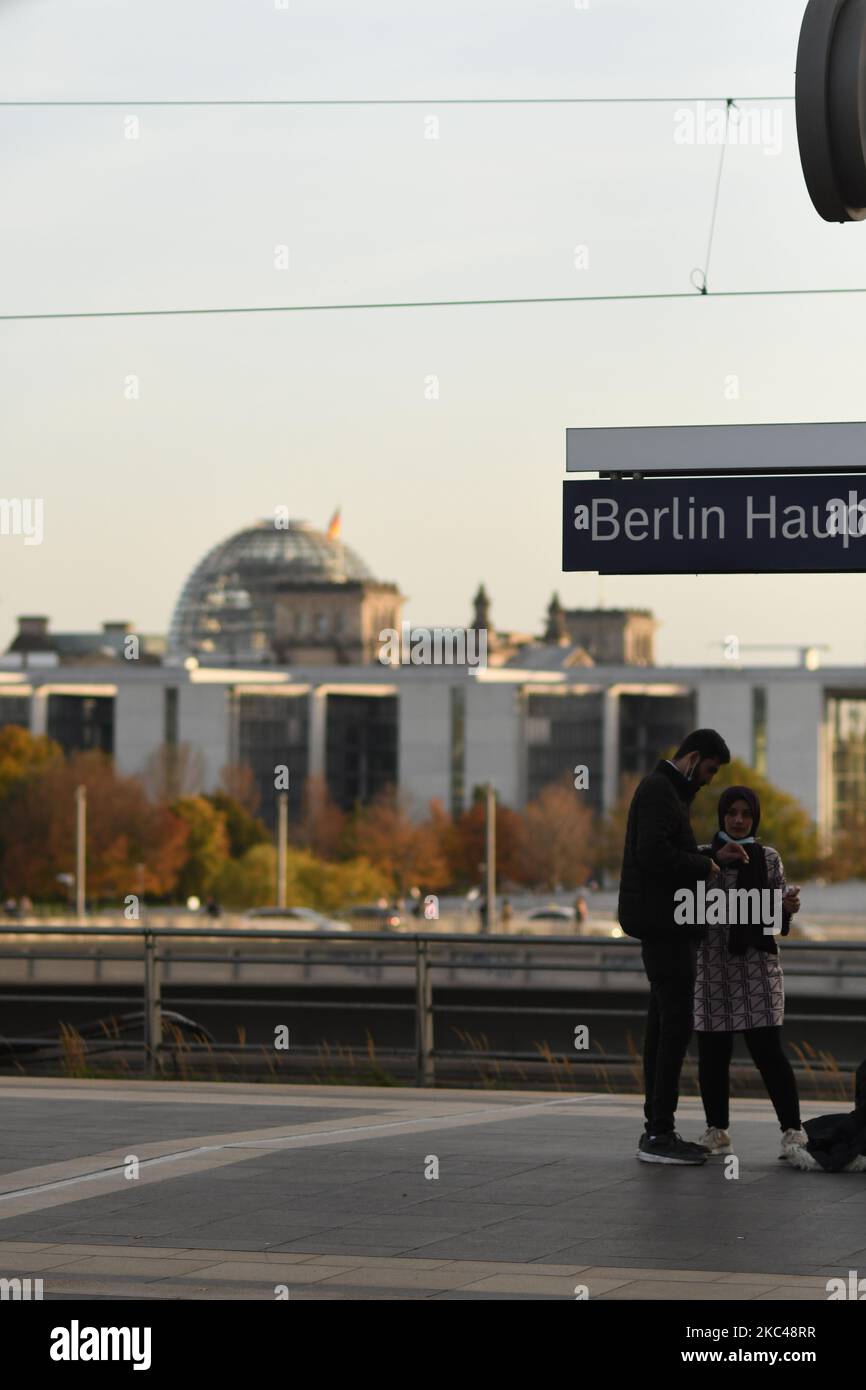Eine vertikale Aufnahme eines Paares, das am Hauptbahnhof mit dem Reichstagsgebäude im Hintergrund in Berlin steht Stockfoto