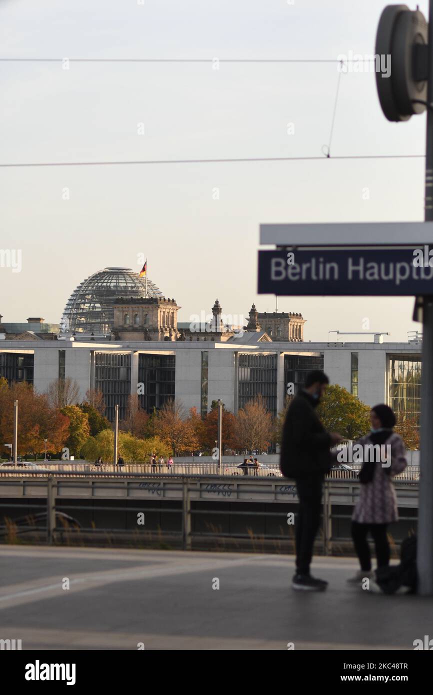 Eine vertikale Aufnahme eines Paares, das am Hauptbahnhof mit dem Reichstagsgebäude im Hintergrund in Berlin steht Stockfoto