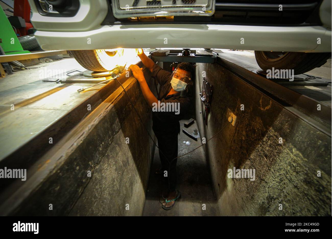Ein Sri-lankischer Arbeiter, Raja, trägt einen Gesichtsschutz und eine Gesichtsmaske und ersetzt einen Reifen in einem Reifenladen, Nandula Radpflege, in Colombo, Sri Lanka. 20. November 2020. Sri Lanka übertraf laut Gesundheitsministerium 19000 bestätigte Covid-19-Patienten mit insgesamt 73 Covid-19-bezogenen Todesfällen und 12903 Genesungen bis Freitag (20). Generalleutnant Shavendra Silva, Chef der Armee Sri Lankas und Leiter des Nationalen Operationszentrums zur Prävention des COVID-19-Ausbruchs (NOCPCO), erklärte, dass die Task Force des Präsidenten auf COVID-19 zusammen mit den srilankischen Gesundheitsbehörden die Lage auf der isola einschätzen Stockfoto