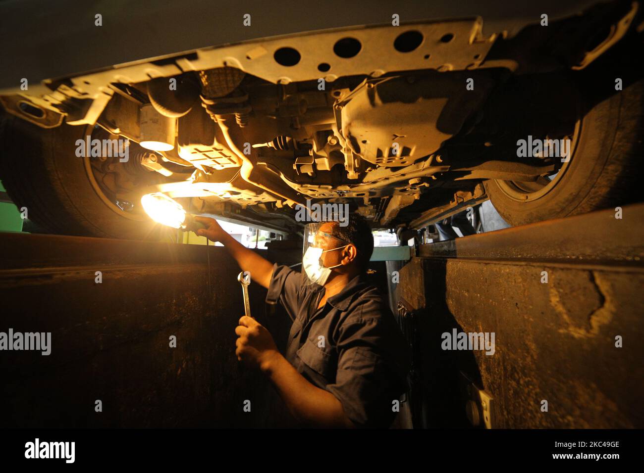 Ein Sri-lankischer Arbeiter, Raja, trägt einen Gesichtsschutz und eine Gesichtsmaske und ersetzt einen Reifen in einem Reifenladen, Nandula Radpflege, in Colombo, Sri Lanka. 20. November 2020. Sri Lanka übertraf laut Gesundheitsministerium 19000 bestätigte Covid-19-Patienten mit insgesamt 73 Covid-19-bezogenen Todesfällen und 12903 Genesungen bis Freitag (20). Generalleutnant Shavendra Silva, Chef der Armee Sri Lankas und Leiter des Nationalen Operationszentrums zur Prävention des COVID-19-Ausbruchs (NOCPCO), erklärte, dass die Task Force des Präsidenten auf COVID-19 zusammen mit den srilankischen Gesundheitsbehörden die Lage auf der isola einschätzen Stockfoto