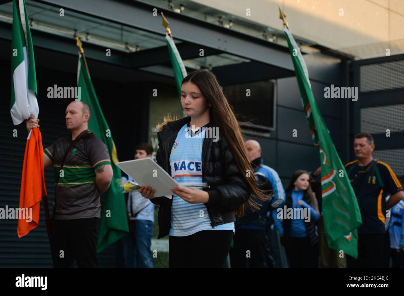 Kinder, die Blumen und Bilder von Opfern des Blutigen Sonntags vor dem Croke Park in Dublin platzieren, während einer Gedenkveranstaltung, die von den „1916 Gesellschaften“ anlässlich des 100. Jahrestages des Blutigen Sonntags organisiert wurde. Der blutige Sonntag war ein Tag der Gewalt in Dublin am 21. November 1920, während des irischen Unabhängigkeitskrieges. Vierzehn unschuldige Menschen (darunter eine Frau, mehrere Kinder und ein Spieler) wurden massakriert, als Mitglieder der britischen Streitkräfte während eines gälischen Fußballspiels im Stadion das Feuer eröffneten. Am Samstag, den 21. November 2020, in Dublin, Irland. (Foto von Artur Widak/NurPhoto) Stockfoto