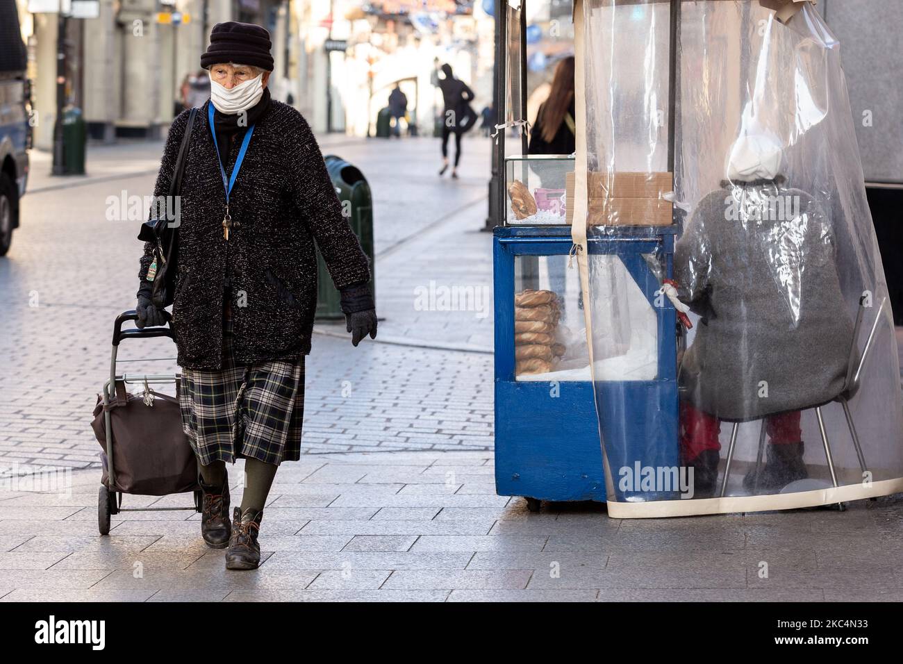 Eine Frau wird gesehen, wie sie an ihrem Straßenstand in der Florianska Straße am Hauptmarkt in Krakaus Altstadt Bagels verkauft, während die Stadt unter teilweiser Coronavirus-Sperre neue Weihnachtsdekorationen anzieht, 26. November 2020. Die Altstadt von Krakau ist in der Regel sehr voll mit Touristen, nicht es bleibt weitgehend verlassen wegen Covid-19 Einschränkungen. (Foto von Dominika Zarzycka/NurPhoto) Stockfoto