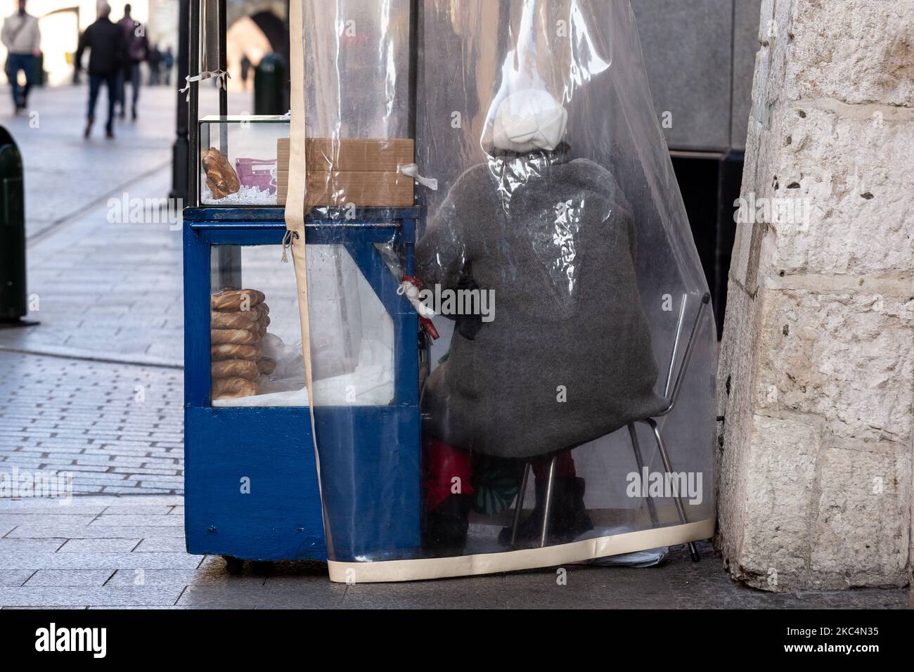 Eine Frau wird gesehen, wie sie an ihrem Straßenstand in der Florianska Straße am Hauptmarkt in Krakaus Altstadt Bagels verkauft, während die Stadt unter teilweiser Coronavirus-Sperre neue Weihnachtsdekorationen anzieht, 26. November 2020. Die Altstadt von Krakau ist in der Regel sehr voll mit Touristen, nicht es bleibt weitgehend verlassen wegen Covid-19 Einschränkungen. (Foto von Dominika Zarzycka/NurPhoto) Stockfoto