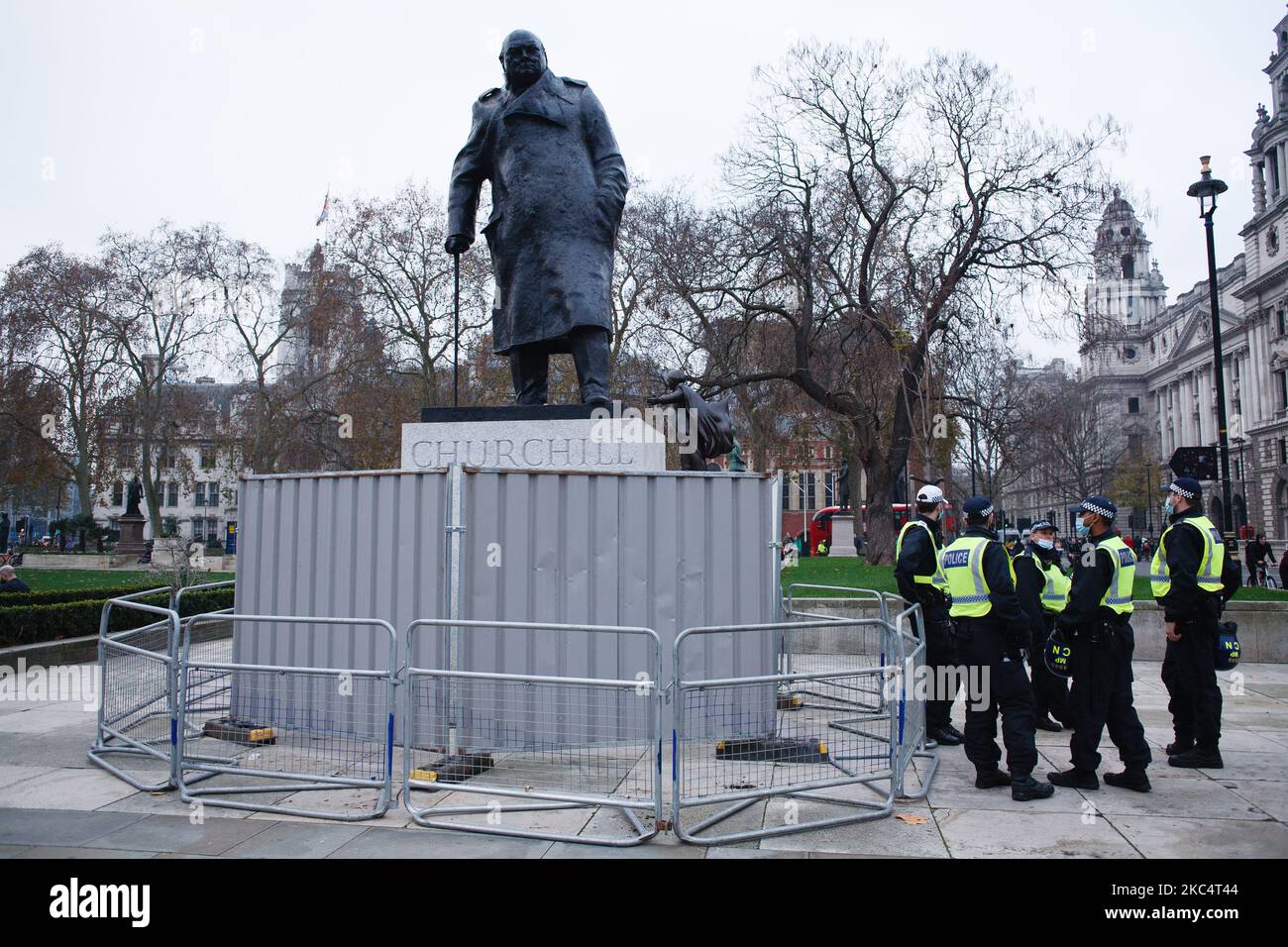 Polizeibeamte stehen neben der Statue des britischen Premierministers Winston Churchill auf dem Parliament Square, die während einer Demonstration von Anti-Lockdown-Aktivisten in London, England, am 28. November 2020 durch Metallzäune verbarrikadiert wurde. London wird zu den „Tier 2“- oder „High Alert“-Covid-19-Beschränkungen zurückkehren, sobald die aktuelle England-weite Sperrung des Coronavirus am kommenden Mittwoch endet. Alle drei Ebenen, die den lokalen Behörden in ganz England zugewiesen wurden, wurden jedoch seit Beginn der Sperre am 5. November verstärkt, wobei die größten Auswirkungen auf den Gastgewerbe zu spüren sind. (Foto von David Cliff/N Stockfoto