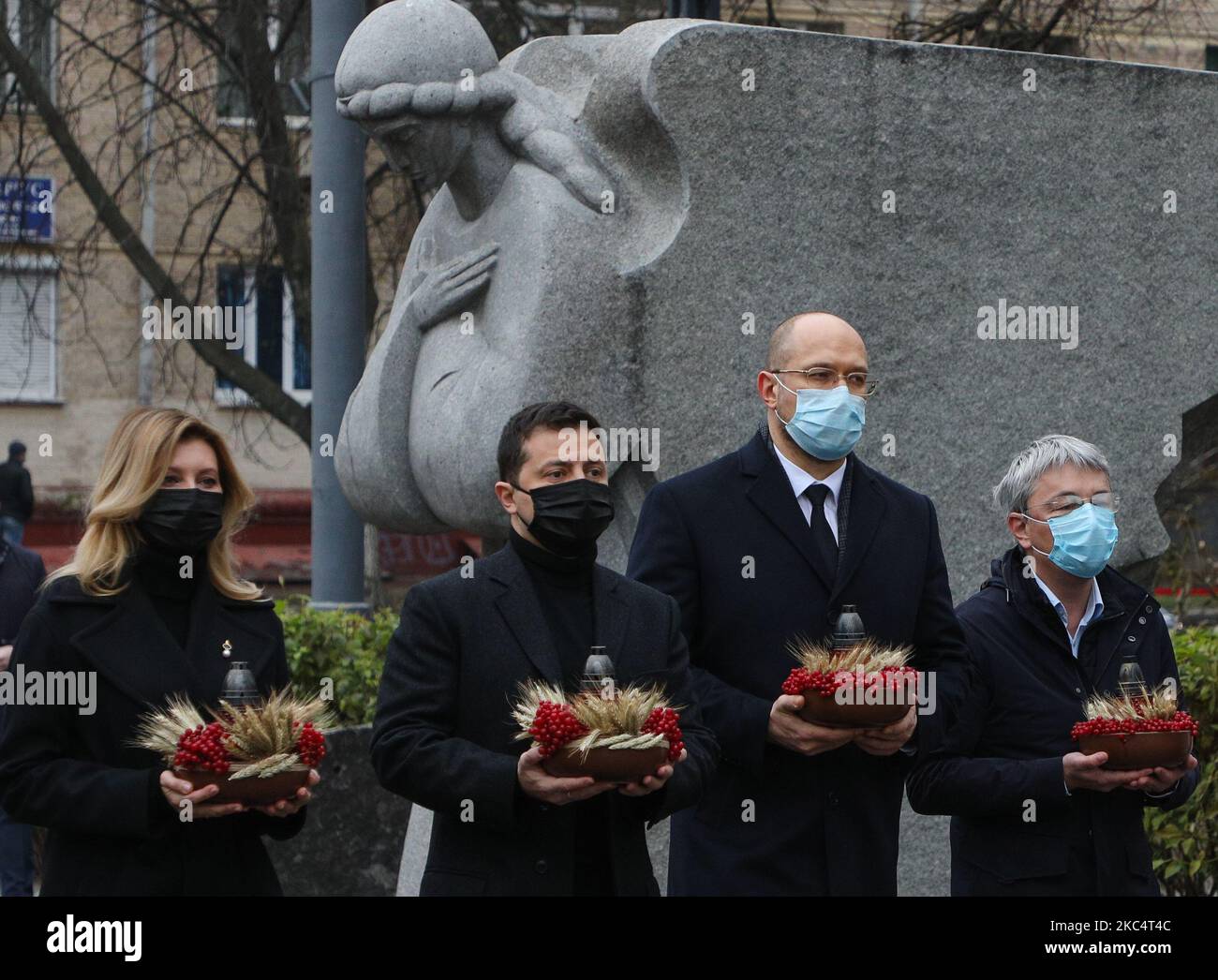 Der Präsident des ukrainischen Volkes Wolodymyr Zelenskiy (2. l), die First Lady Olena Zelenska (L) und der ukrainische Premierminister Denys Shmyhal (2. R) zündeten Kerzen an und legten während der Trauerkundgebung in Kiew, Ukraine, am 28. November 2020, Blumensträuße von den Ohren und dem arrowwood zum Denkmal der großen Hungeropfer. Die Ukraine ehrt das Gedenken an die Opfer der Hungersnot und der Großen Hungersnot (Holodomor) von 1932 bis 1933, als 4,5 Millionen Ukrainer, darunter 600.000 ungeborene Kinder, vom sowjetischen Regime unter Joseph Stalin verhungert wurden. (Foto von Sergii Chartschenko/NurPhoto) Stockfoto