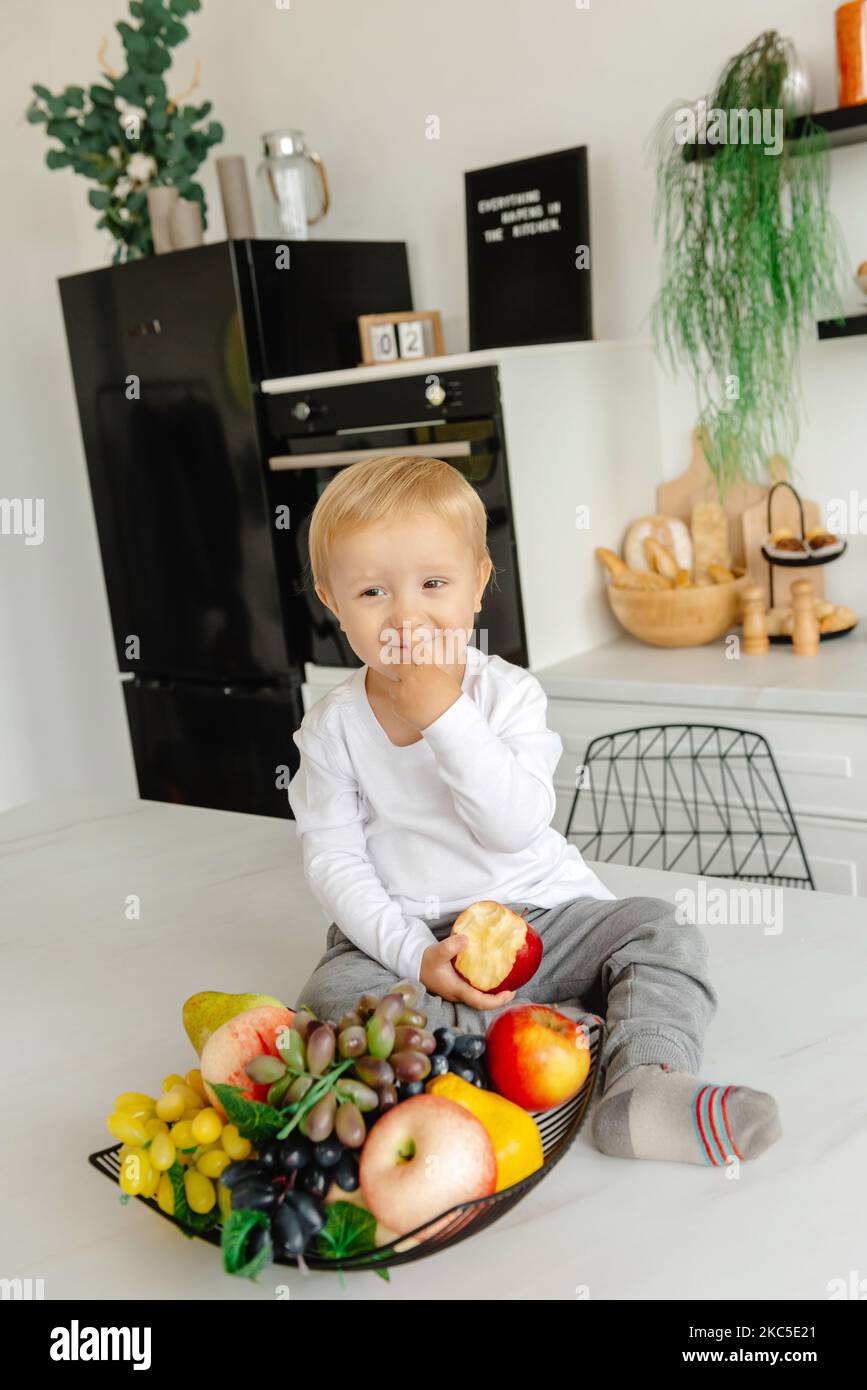 Ein Kind pflückt sich in der Küche die Nase Stockfoto
