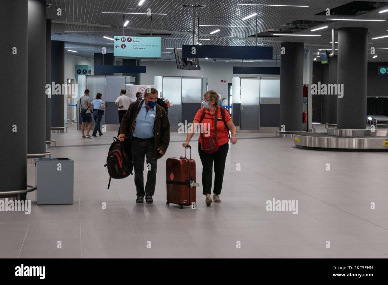 Das Innere des neuen Terminals des internationalen Flughafens Thessaloniki Makedonia SKG LGTS. Der neu errichtete und eröffnete Gepäckbandbereich, die Ankunftshalle des zweiten Terminals, das nach der Privatisierung von Fraport Greece, dem Betreiber des Flughafens, gebaut wurde. Am Gepäckabholbereich werden ankommende Passagiere von Inlandsflügen mit Gesichtsmask aufgrund der Sicherheitsmaßnahmen des Coronavirus gesehen. Der weltweite Personenverkehr ging während der Pandemie des Coronavirus Covid-19 zurück, und die Industrie kämpfte ums Überleben. Im Moment erlaubt die Regierung mit einem NOTAM nur das wesentliche Reisen als Stockfoto