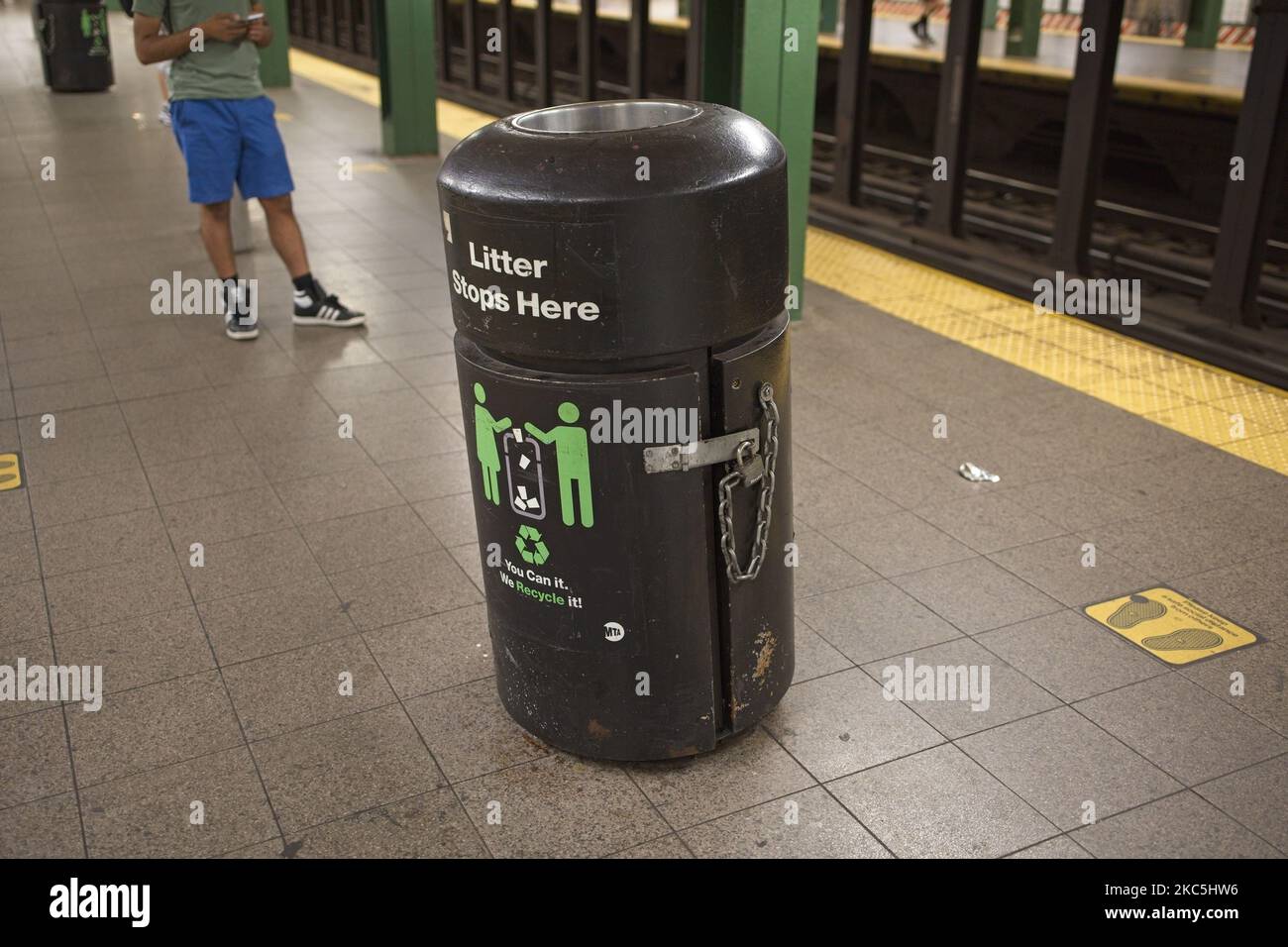 New York, NY, USA - 4. Nov 2022: Ein Mülleimer in einem verketteten Metallcontainer, um zu verhindern, dass der Mülleimer auf die nahe gelegenen U-Bahnschienen geschoben wird Stockfoto