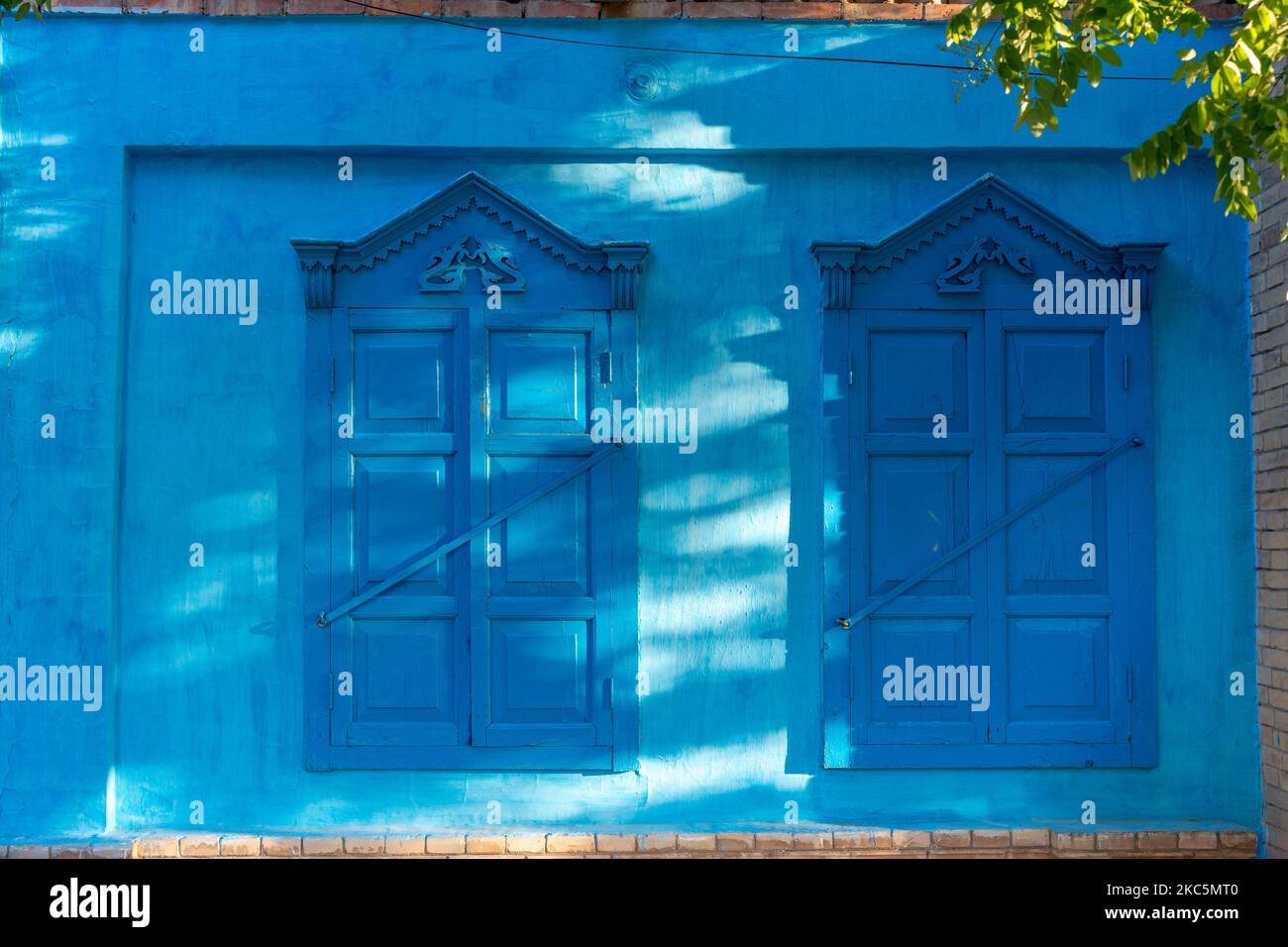 Das Äußere eines blauen Gebäudes mit Holzfenstern Stockfoto