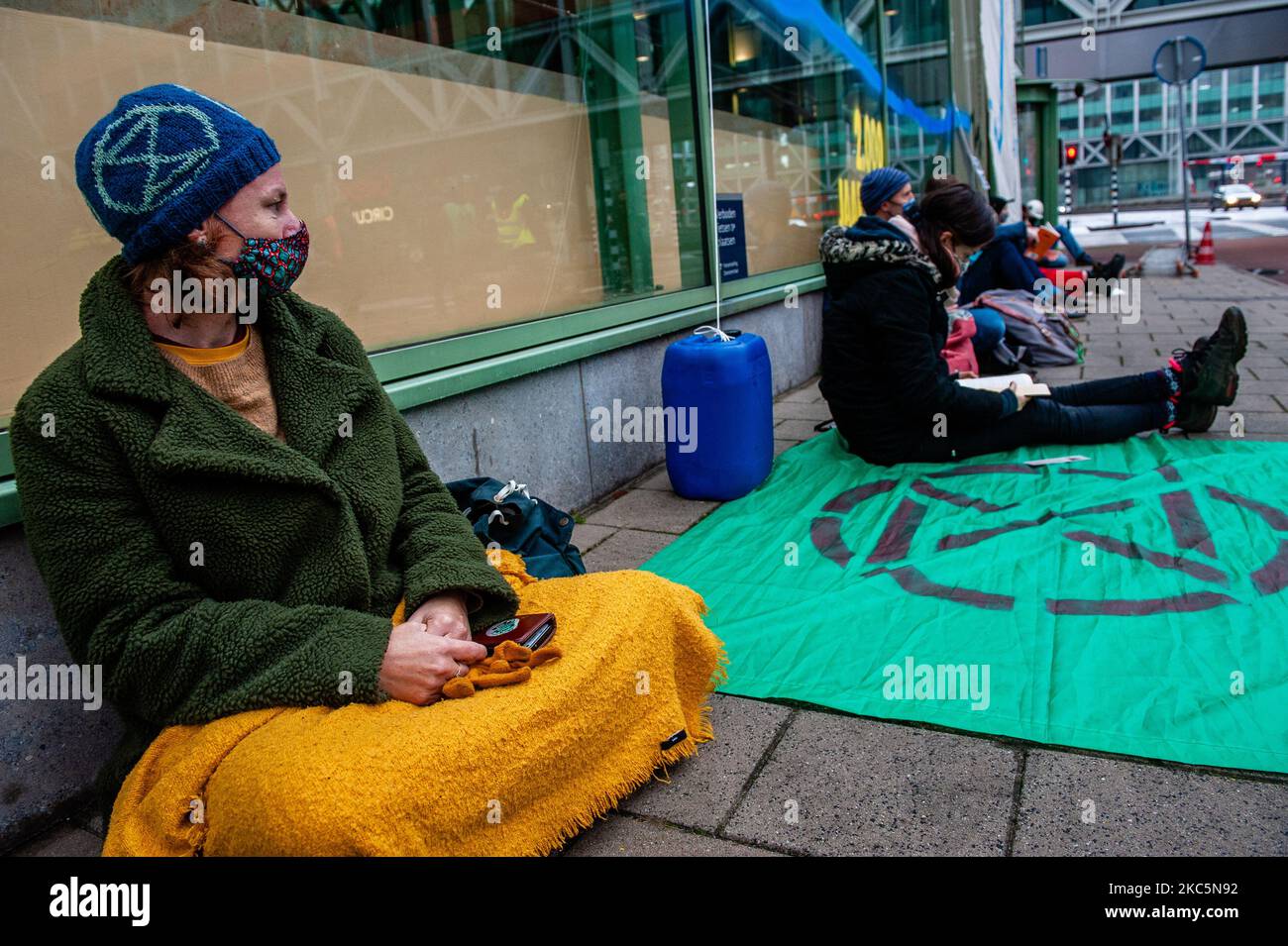 Extinction Rebellion Aktivisten sitzen vor dem Gebäude des Wirtschaftsministeriums und der Klimapolitik in Den Haag, wo die Aktivisten am 12.. Dezember 2020 ein riesiges Banner aufgehängt und einige Sprühbilder zur Erwärmung des Klimawandels angebracht haben. (Foto von Romy Arroyo Fernandez/NurPhoto) Stockfoto