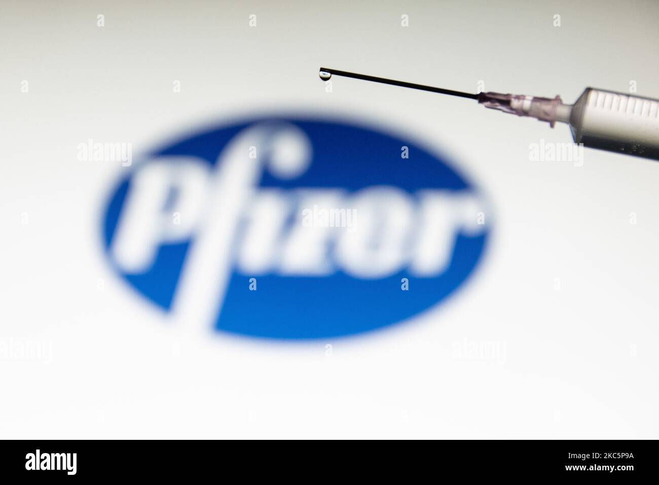 Foto-Illustration einer medizinischen Spritze mit einer Nadel, die vor dem Logo des Pharmakonzerns von Pfizer zu sehen ist. Großbritannien hat den Pfizer/BioNTech-Impfstoff zugelassen und eingeführt, während die FDA den COVID-19-Impfstoff für den Notfall in den USA zugelassen hat, wie von amerikanischen Medien berichtet wurde. Die Coronavirus-Pandemie, eine der größten Gesundheitskrisen der Welt, wird zu dem größten Impfprogramm in der menschlichen Geschichte führen. Amsterdam, Niederlande am 12. Dezember 2020 (Foto von Nicolas Economou/NurPhoto) Stockfoto