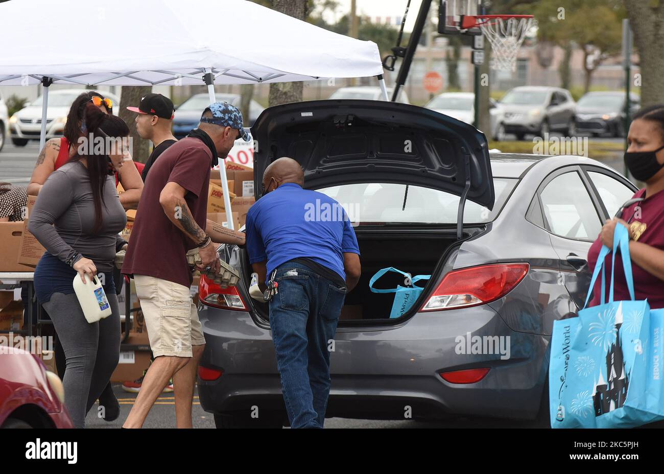 Freiwillige beladen Autos mit Puten und anderer Nahrungsmittelhilfe für entlassen Walt Disney World Cast Mitglieder und andere auf einer Food Distribution Veranstaltung am 12. Dezember 2020 in Orlando, Florida. Tom und Sarah Bricker, ein Paar, das den Disney Tourist Blog leitet, haben über $64.000 Online-Spenden für die Second Harvest Food Bank of Central Florida gesammelt, die sich mit Good Samaritan Outreach zusammenschmissen hat, um den arbeitslosen Themenparkmitarbeitern zu helfen. (Foto von Paul Hennessy/NurPhoto) Stockfoto