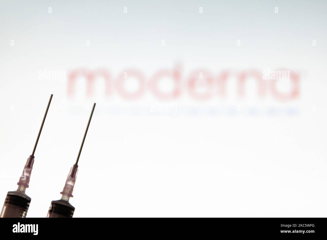 Foto-Illustration einer medizinischen Spritze mit einer Nadel vor dem Logo des Pharmakonzerns Moderna. Moderna erwartet die amerikanische Entscheidung, eine Zulassung für die Notfallverwendung, den Impfstoffkandidaten mRNA-1273 am 17 2020. Dezember von der FDA und die europäische Zulassung für den COVID-19-Impfstoff im Januar 2021. Moderna ist ein amerikanisches Biotechnologie-Unternehmen mit Sitz in Cambridge, Massachusetts, das Impfstofftechnologien auf Basis von Boten-RNA mRNA entwickelt. Die Coronavirus-Pandemie, eine der größten Gesundheitskrisen der Welt, wird zu dem größten Impfprogramm in der menschlichen Geschichte führen. Amste Stockfoto
