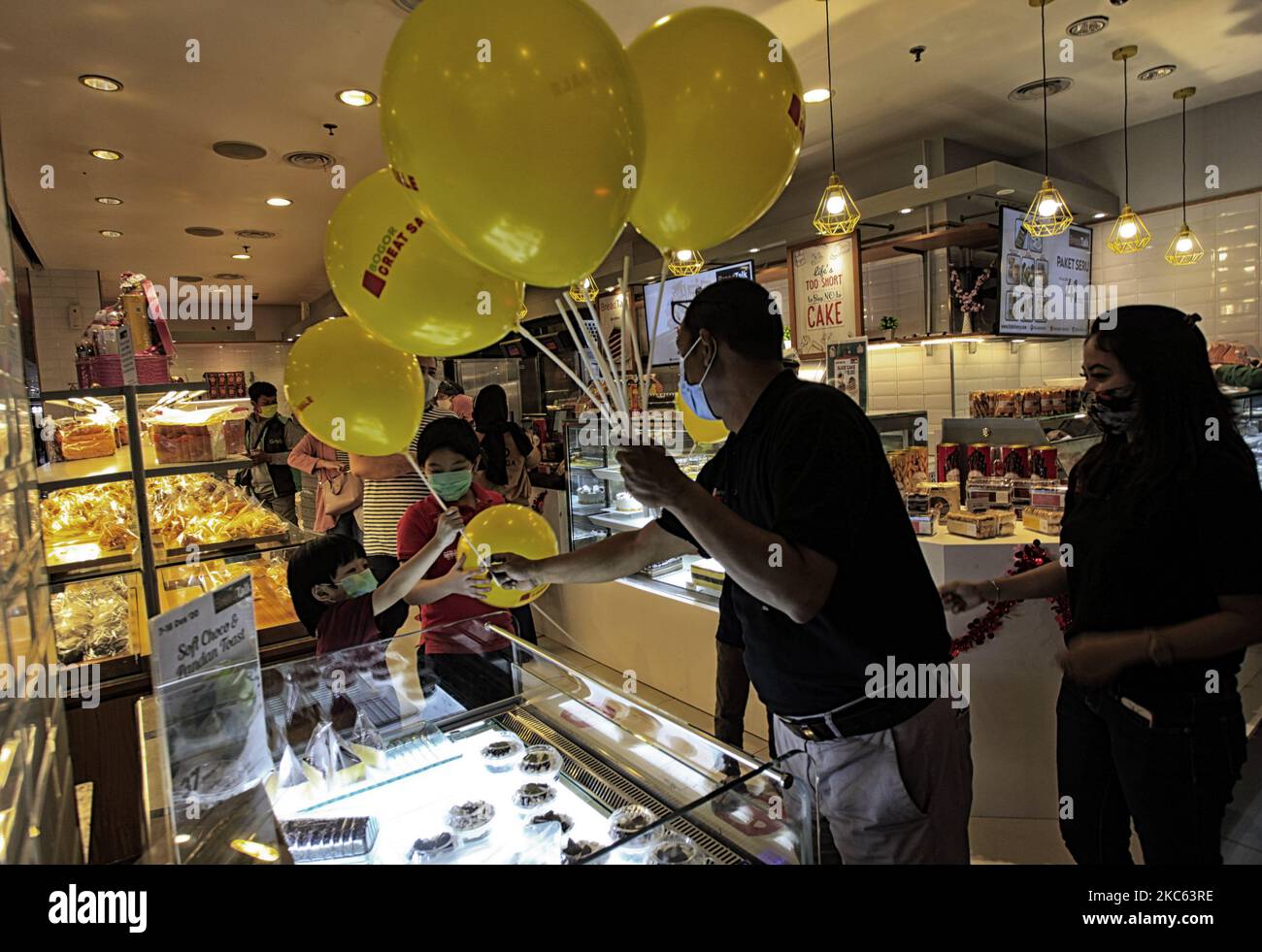 Am 18. Dezember 2020 übergibt ein Offizier eines Einkaufszentrums einem Besucher des Einkaufszentrums Botani Square in Bogor City, West Java, Indonesien, während des „Bogor Great Sale“-Programms einen Ballon, um die Wirtschaft zu erholen und die Besucher des Einkaufszentrums während der COVID-19-Pandemie zu erhöhen. (Foto von Adriana Adie/NurPhoto) Stockfoto