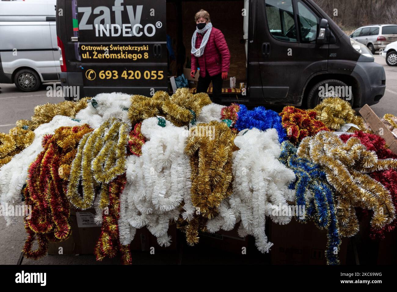 Eine Frau in einer schützenden Gesichtsmaske wird an einem kalten und frostigen Wintertag auf einem Straßenmarkt Weihnachtsbaumschmuck verkaufen sehen, während sich die Weihnachtsfestzeit unter teilweiser Coronavirus-Sperre am 21. Dezember 2020 in Ostrowiec Swietokrzyski, Polen, nähert. Dicke Wolken bedecken den größten Teil Europas und schaffen eine trübe Tagesatmosphäre, was die pandemische Frustration im polnischen Provinzgebiet verstärkt. (Foto von Dominika Zarzycka/NurPhoto) Stockfoto