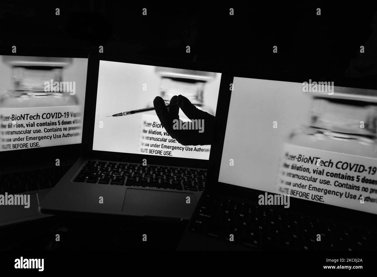 Ein illustratives Bild einer medizinischen Spritze vor einem Bild eines Fläschchens mit Pfizer-BioNTech-Impfstoff, das auf Bildschirmen angezeigt wird. Am Montag, den 28. Dezember 2020, in Dublin, Irland. (Foto von Artur Widak/NurPhoto) Stockfoto