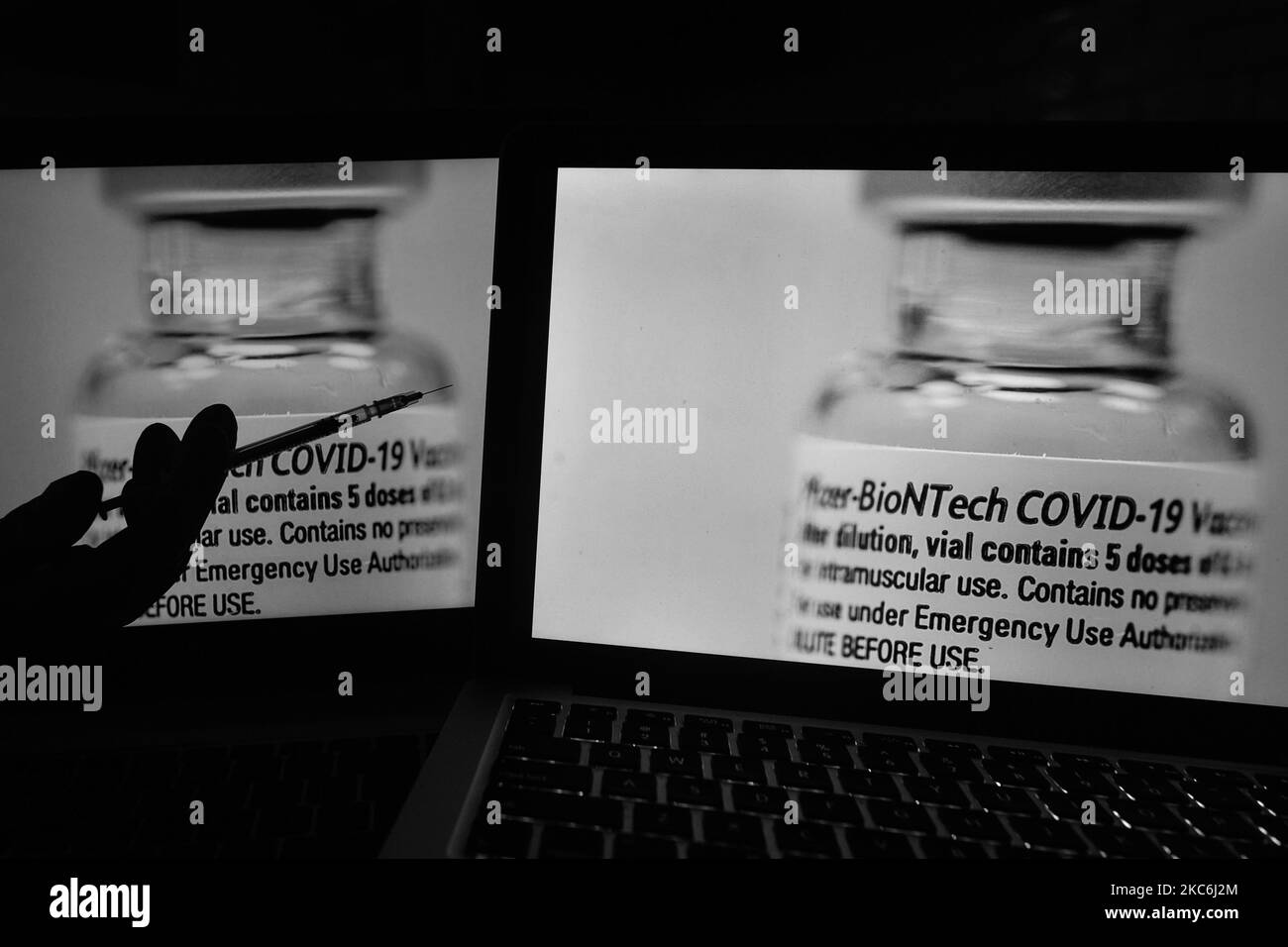 Ein illustratives Bild einer medizinischen Spritze vor einem Bild eines Fläschchens mit Pfizer-BioNTech-Impfstoff, das auf Bildschirmen angezeigt wird. Am Montag, den 28. Dezember 2020, in Dublin, Irland. (Foto von Artur Widak/NurPhoto) Stockfoto