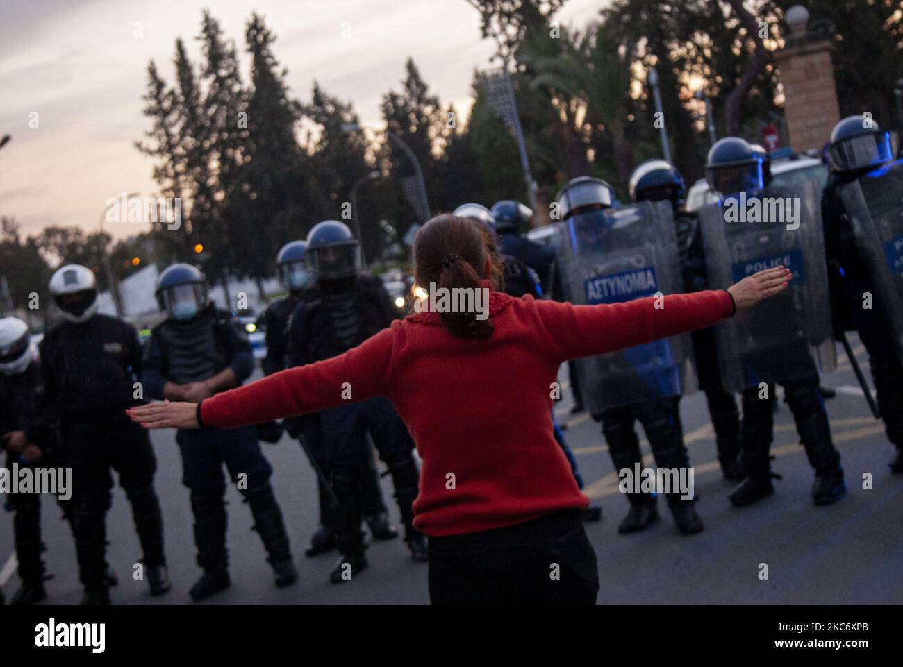 Eine Protesterin hebt ihre Hände vor der Polizei während eines friedlichen Protestes vor dem Präsidentenpalast in Nikosia am 03. Januar 2021 gegen die Regierung und die Maßnahmen, die sie gegen das Coronavirus ergreift. (Foto von George Christophorou/NurPhoto) Stockfoto