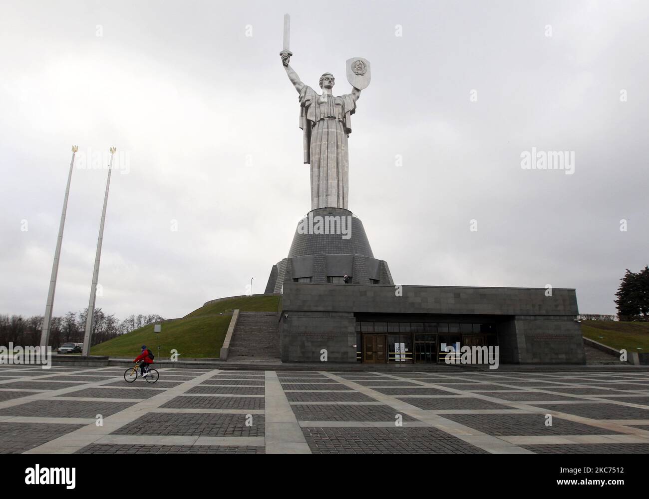 Am 08. Januar 2021 fährt ein Radfahrer am Mutterlanddenkmal im Nationalmuseum für Geschichte der Ukraine im Zweiten Weltkrieg in Kiew, Ukraine, vorbei. Wie lokale Medien berichteten, führte die Ukraine eine landesweite Sperrung durch und verschärft die epidemische Quarantäne, um die Ausbreitung der COVID-19-Coronavirus-Pandemie einzudämmen. Von 8. Januar bis 24. Januar ist es verboten, Cafés, Bars, Restaurants (mit Ausnahme des Verkaufs von Takeaway und Lieferung), Märkte, Einkaufs-und Unterhaltungszentren, Kinos, Theater, Turnhallen, nach Medien zu arbeiten. (Foto von STR/NurPhoto) Stockfoto