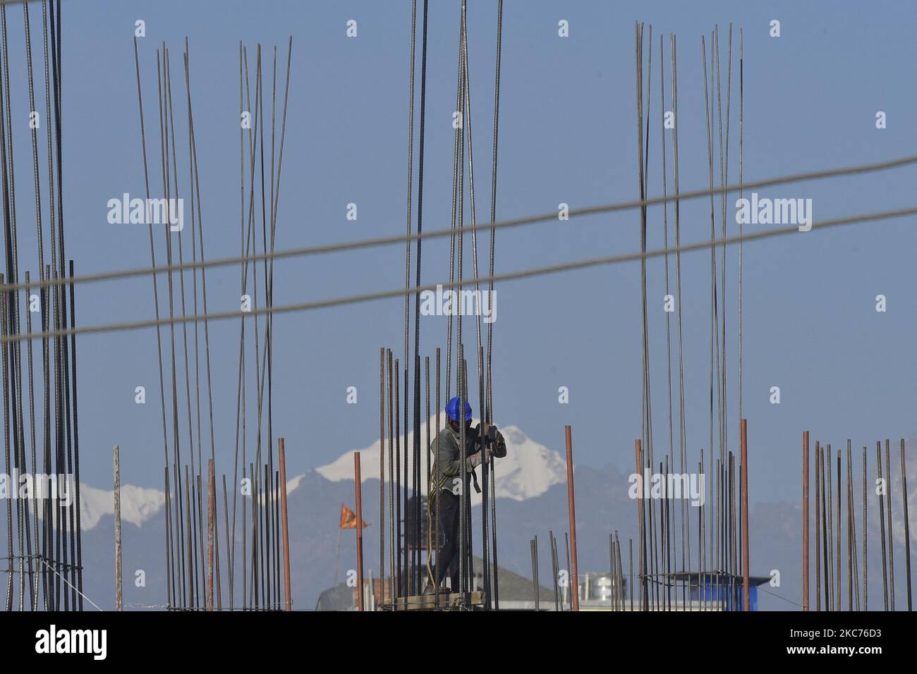 Arbeiter, die am Bau eines neuen Gebäudes als Berge im Hintergrund in Kathmandu, Nepal, am Freitag, 8. Januar 2021 arbeiten. (Foto von Narayan Maharjan/NurPhoto) Stockfoto