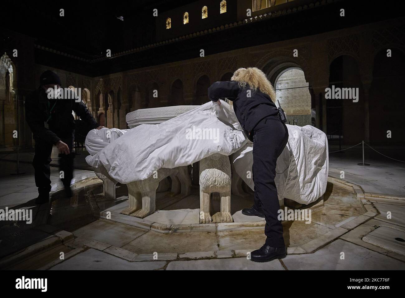 Die Arbeiter der Alhambra schützen die Löwen des berühmten Löwenbrunnens in der Alhambra mit einer speziellen thermischen Abdeckung aufgrund der niedrigen Temperaturen, die mit dem Sturm Filomena am 9. Januar 2020 in Granada, Spanien, erwartet werden. Spanien ist am zweiten Tag aufgrund des Sturms Filomena, der ungewöhnlich kaltes Wetter und starken Schneefall gebracht hat, in Alarmstufe Rot. Der Löwenbrunnen im Patio de los Leones de la Alhambra wurde nach 10 Jahren Restaurierung aufgrund des schlechten Zustands der Wasserkreisläufe und des Zeitverlaufes wieder eröffnet und erfordert besondere Sorgfalt, um erhebliche Schäden zu vermeiden. (Foto von Fermin RO Stockfoto