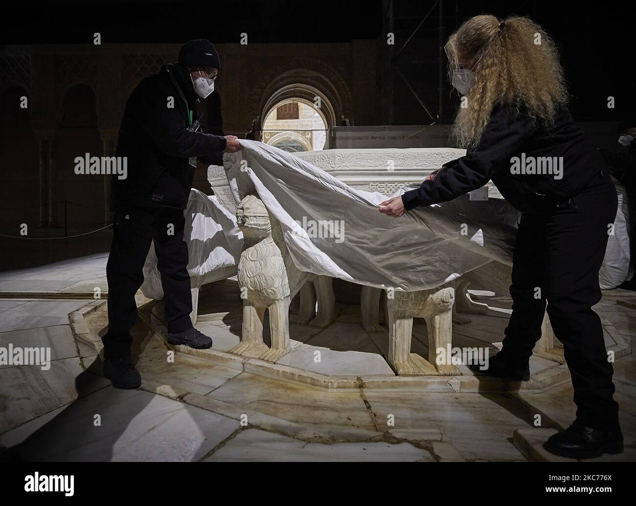 Die Arbeiter der Alhambra schützen die Löwen des berühmten Löwenbrunnens in der Alhambra mit einer speziellen thermischen Abdeckung aufgrund der niedrigen Temperaturen, die mit dem Sturm Filomena am 9. Januar 2020 in Granada, Spanien, erwartet werden. Spanien ist am zweiten Tag aufgrund des Sturms Filomena, der ungewöhnlich kaltes Wetter und starken Schneefall gebracht hat, in Alarmstufe Rot. Der Löwenbrunnen im Patio de los Leones de la Alhambra wurde nach 10 Jahren Restaurierung aufgrund des schlechten Zustands der Wasserkreisläufe und des Zeitverlaufes wieder eröffnet und erfordert besondere Sorgfalt, um erhebliche Schäden zu vermeiden. (Foto von Fermin RO Stockfoto