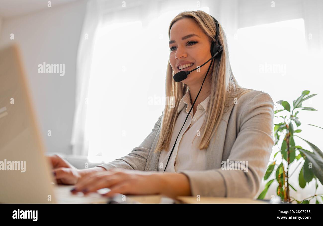 Junge Frau, die im Callcenter arbeitet. Kundendienstfrau im Büro Stockfoto