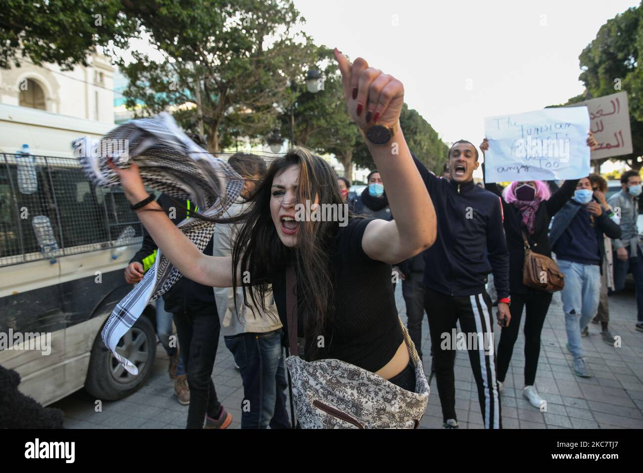 Eine junge Protesterin, die während einer Demonstration am 19. Januar 2021 auf der Avenue Habib Bourguiba in der tunesischen Hauptstadt Tunis gegen die Regierung des Premierministers Hichem Mechichi protestiert, schreit regierungsfeindliche Parolen, Und zur Unterstützung der Protestbewegungen, die Tunesien in mehreren Städten über Nacht in den vergangenen Tagen getroffen haben. Demonstranten prallten mit den Sicherheitskräften zusammen, die Tränengas abfeuerten und Pfefferspray verwendeten, um sie zu zerstreuen. Sie forderten auch die Freilassung von Jugendlichen, die während der letzten Proteste von der Polizei verhaftet wurden, und verurteilten die hohen Kosten dafür Stockfoto