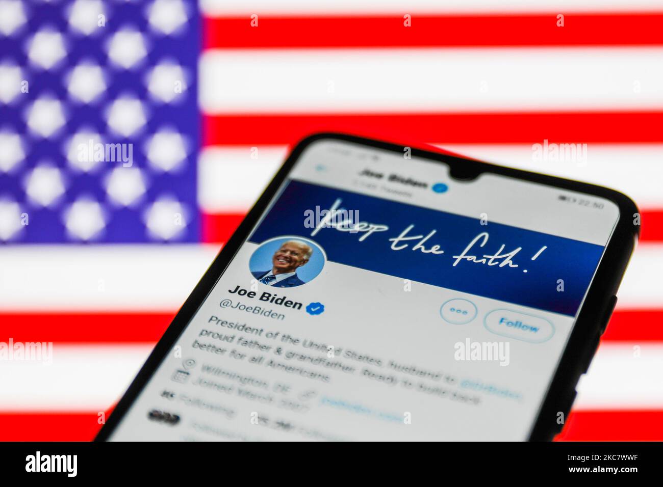 Der Twitter-Account des US-Präsidenten Joe Biden ist auf einem Telefonbildschirm mit amerikanischer Flagge im Hintergrund zu sehen, auf diesem Bild, das am 20. Januar 2021 aufgenommen wurde. (Foto-Illustration von Jakub Porzycki/NurPhoto) Stockfoto