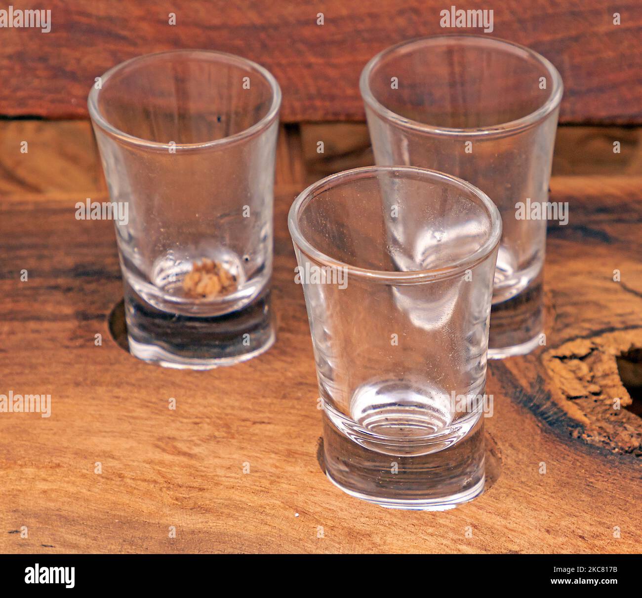 Kleine leere Glasschüsse auf einem Tablett aus zurückgewonnenen Holz Stockfoto