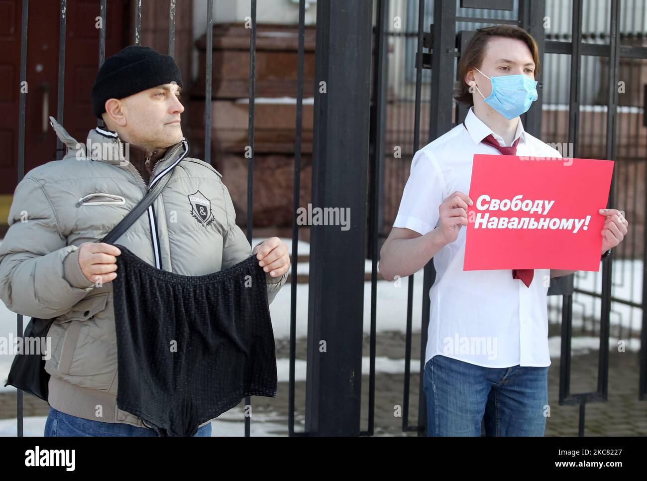 Ein Aktivist hält am 23. Januar 2021 bei einer Kundgebung zur Unterstützung des russischen Oppositionsführers Alexej Nawalny gegen seine Inhaftierung in der Nähe der russischen Botschaft in Kiew, Ukraine, ein Plakat mit der Aufschrift „Freiheit für Alexej Nawalny“, während ein anderer eine Unterhose hält. (Foto von STR/NurPhoto) Stockfoto
