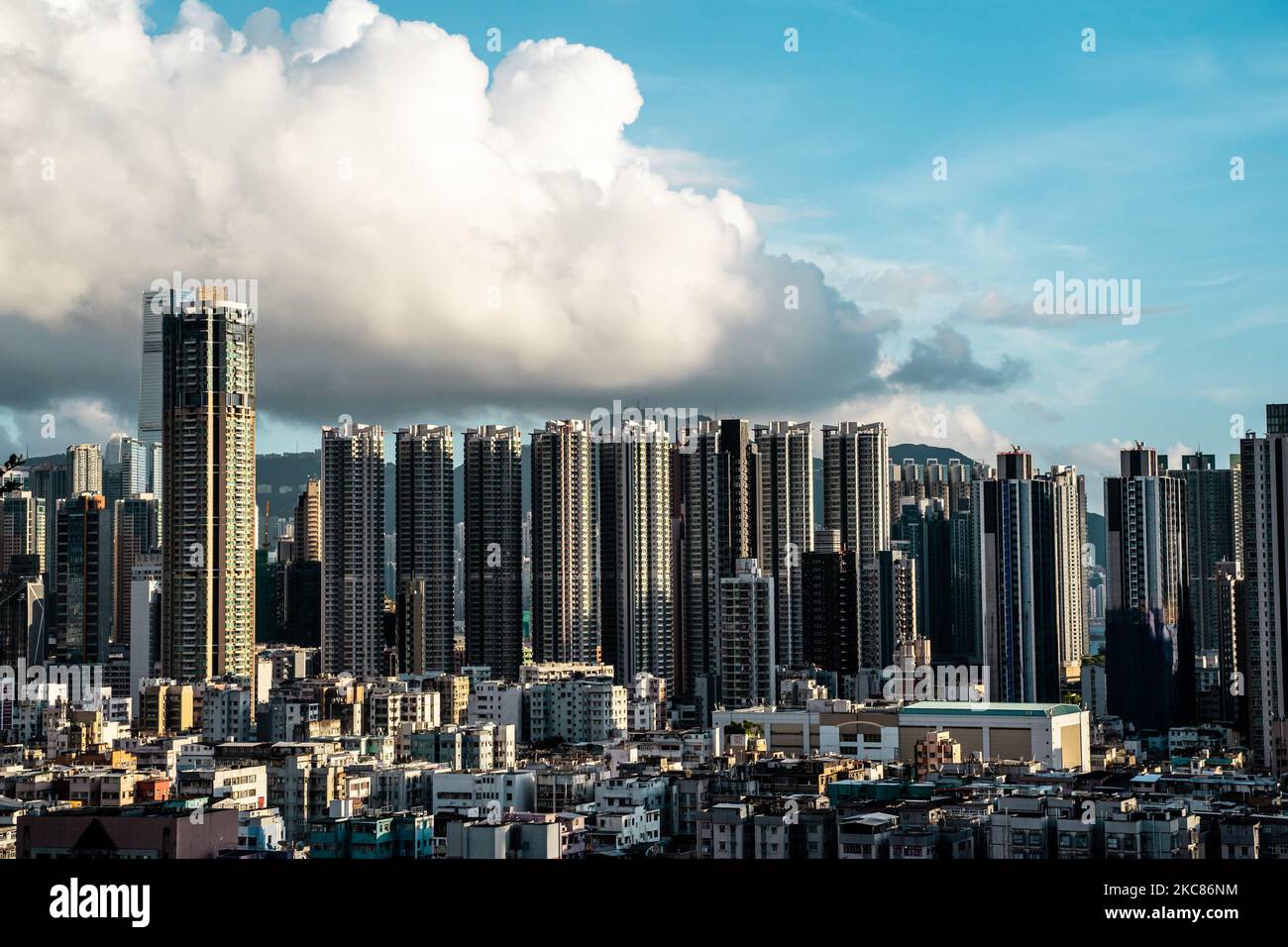 Das Wohnviertel in der Altstadt von Hongkong im Vergleich zu modernen Gebäuden unter blauem bewölktem Himmel Stockfoto