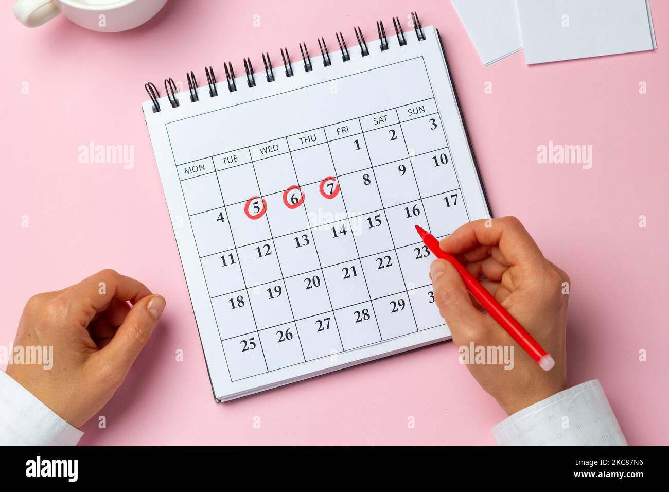 Das Konzept des Menstruationszyklus, Periode. Die Frau markiert die Tage auf dem Kalender. Stockfoto