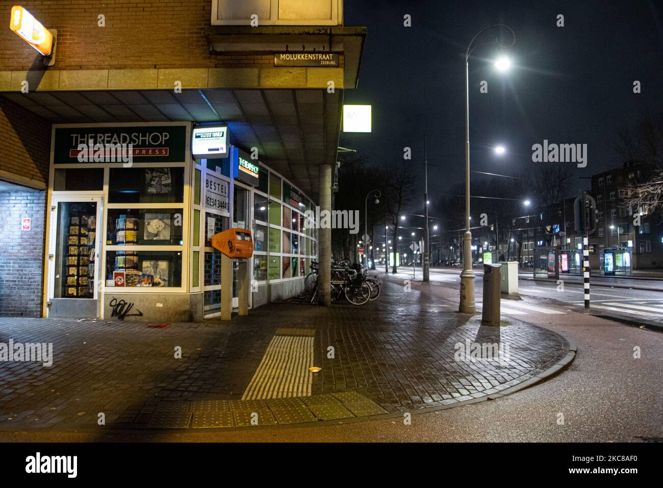 Leere und ruhige Straßen der niederländischen Stadt Amsterdam während der COVID-Ausgangssperre. Menschen können nur mit einem nachgewiesenen Grund und einer besonderen Erlaubnis mit entsprechenden Unterlagen draußen sein, sonst werden sie 95euro, zur Nachtauszeit, zu einer Geldstrafe verurteilt. Öffentliche Verkehrsmittel wie Bus und Straßenbahn fahren leer. Polizeibeamte und Fahrzeuge, die in Amsterdam eingesetzt wurden, um die Ausgangssperre zu überblicken. Menschenleere Straßen der werden am vierten Tag mit der Ausgangssperre im Land gesehen, ruhiger nach gewalttätigen Protesten und Zusammenstößen in den Vortagen. Die Regierung verhängte die Ausgangssperre, um die Ausbreitung des Virus nach der Lockd zu bekämpfen Stockfoto