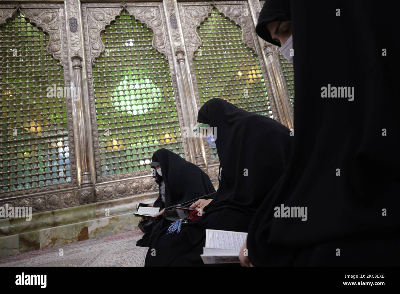 Verschleierte iranische Frauen. Mit Schutzmasken beten sie am ersten Tag des Sieges des Jahrestages der Islamischen Revolution auf dem Friedhof Behesht-e Zahra im Süden Teherans, während der COVID-19-Ausbruch im Iran am 1. Januar, neben dem Grab des verstorbenen iranischen Führers Ayatollah Ruhollah Khomeini, sitzt 31, 2021. Der Iran feiert zehn Tage nach dem heutigen Tag den 42.. Jahrestag des Sieges der Islamischen Revolution, aber der Ausbruch der neuen Coronavirus-Krankheit (COVID-19) hat die diesjährigen Feierlichkeiten nicht wie in den vergangenen Jahren gefeiert. (Foto von Morteza Nikoubazl/NurPhoto) Stockfoto
