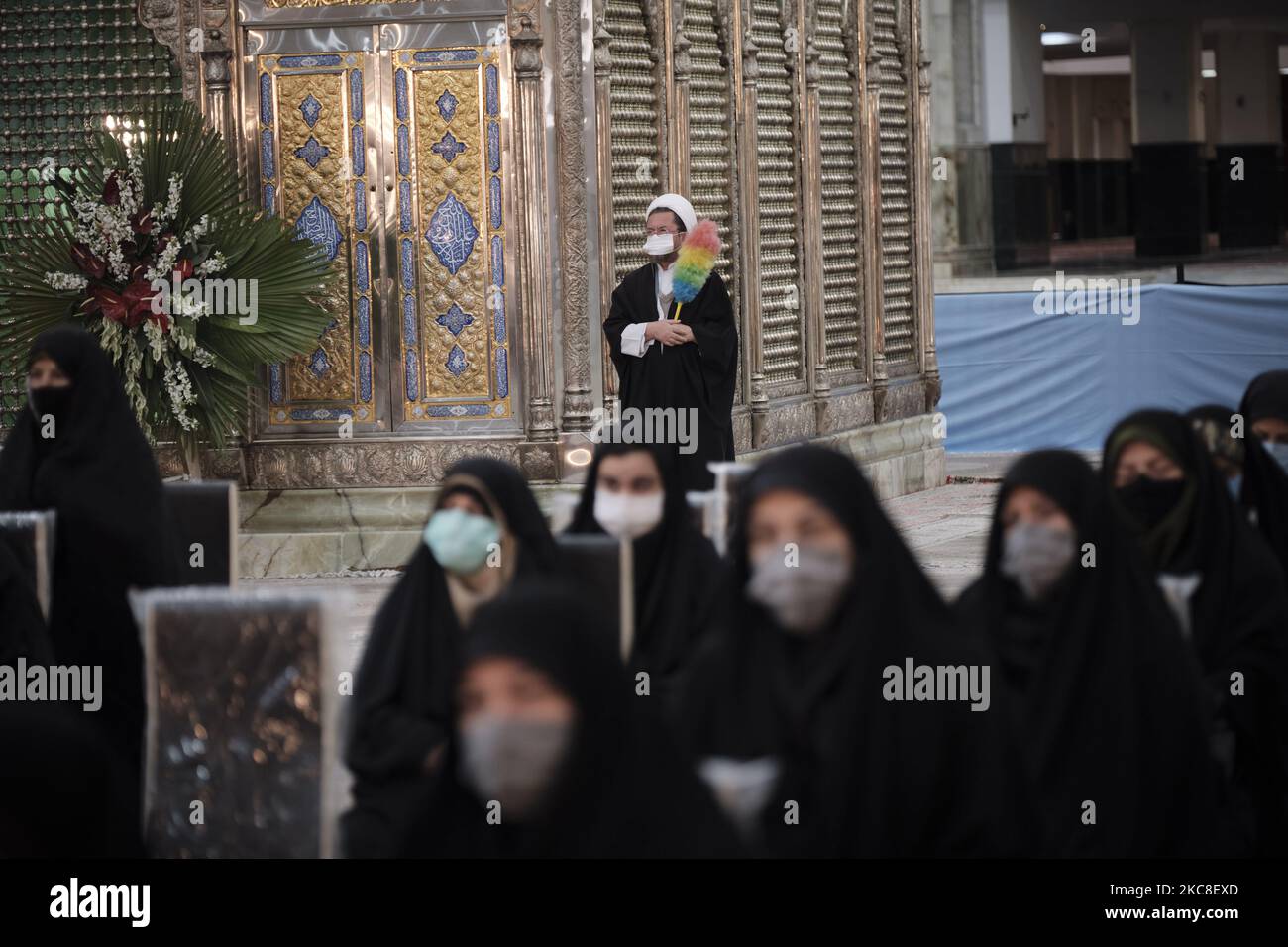 Ein iranischer Geistlicher, der eine Schutzmaske trägt, während er am ersten Tag des Sieges des Jahrestages der Islamischen Revolution auf dem Friedhof Behesht-e Zahra im Süden Teherans inmitten des COVID-19-Ausbruchs im Iran am 31. Januar neben dem Grab des verstorbenen iranischen Führers Ayatollah Ruhollah Khomeini steht, 2021. Der Iran feiert zehn Tage nach dem heutigen Tag den 42.. Jahrestag des Sieges der Islamischen Revolution, aber der Ausbruch der neuen Coronavirus-Krankheit (COVID-19) hat die diesjährigen Feierlichkeiten nicht wie in den vergangenen Jahren gefeiert. (Foto von Morteza Nikoubazl/NurPhoto) Stockfoto