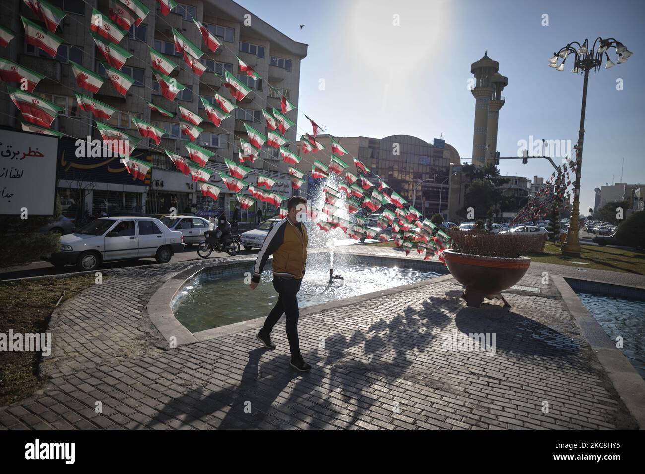 Ein Iraner geht am 1. Februar 2021 in der Innenstadt von Teheran auf dem Platz Fatemi, der mit iranischen Fahnen geschmückt ist, während der zehntägigen Feierlichkeiten zum 42. Jahrestag des Sieges der Islamischen Revolution des Iran. (Foto von Morteza Nikoubazl/NurPhoto) Stockfoto