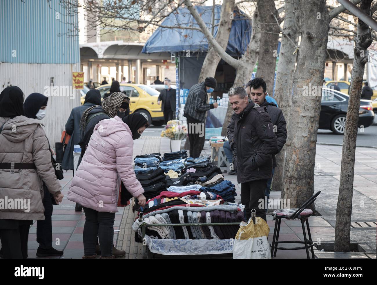 Eine iranische Frau kauft bei einem Händler auf einer Straße im Norden Teherans während der zehntägigen Feierlichkeiten zum 42. Jahrestag des Sieges der Islamischen Revolution im Iran am 1. Februar 2021. (Foto von Morteza Nikoubazl/NurPhoto) Stockfoto