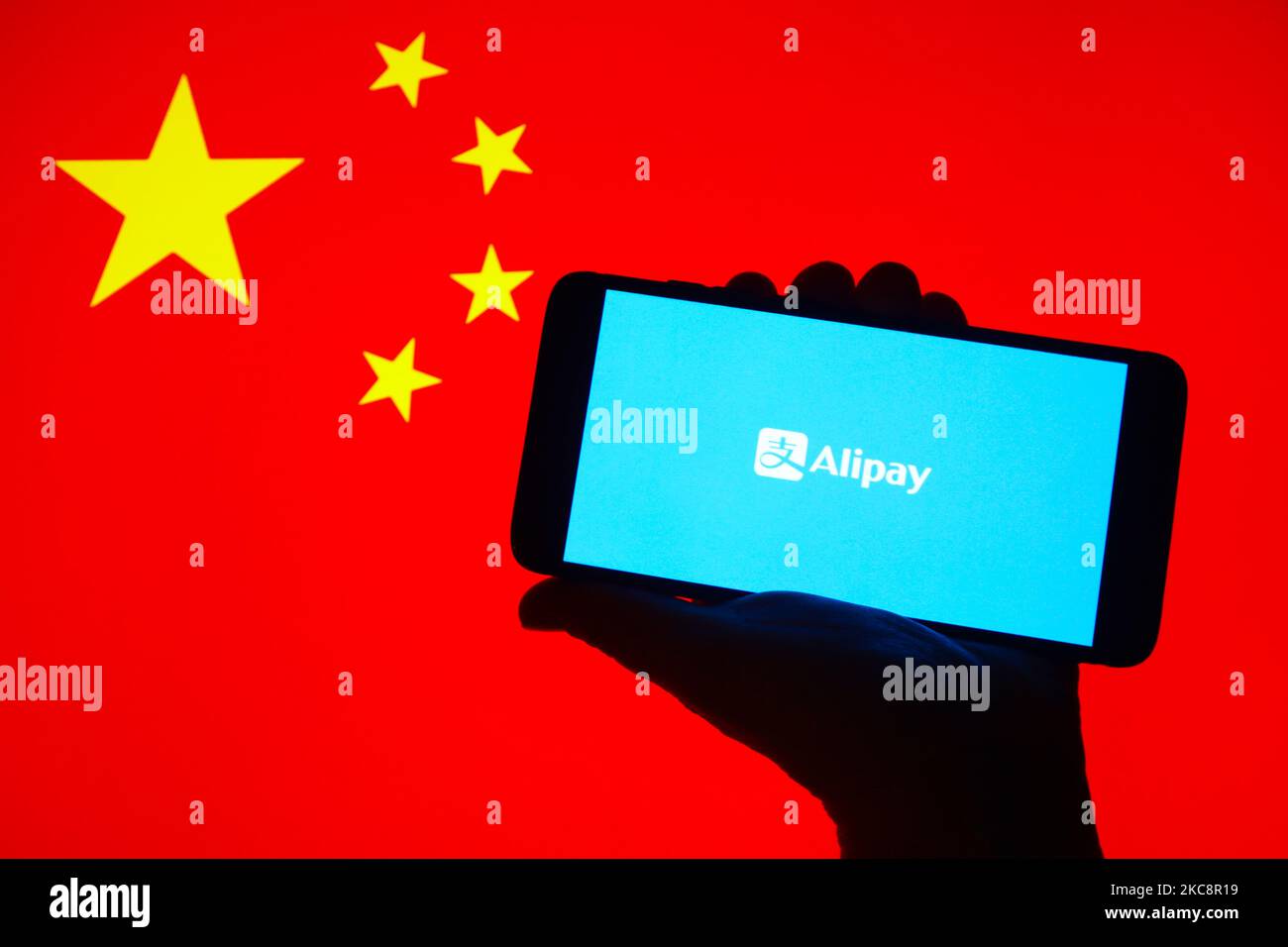 Das Alipay App-Logo wird auf einem Handybildschirm mit chinesischer Flagge angezeigt. Krakau, Polen, am 5. Februar 2021. Die chinesische Alipay-App hat mehr als 700 Millionen monatliche Nutzer, die sie verwenden, um zu bezahlen, Kredite aufzunehmen, zu versichern und ihr Geld zu verwalten. (Foto-Illustration von Beata Zawrzel/NurPhoto) Stockfoto