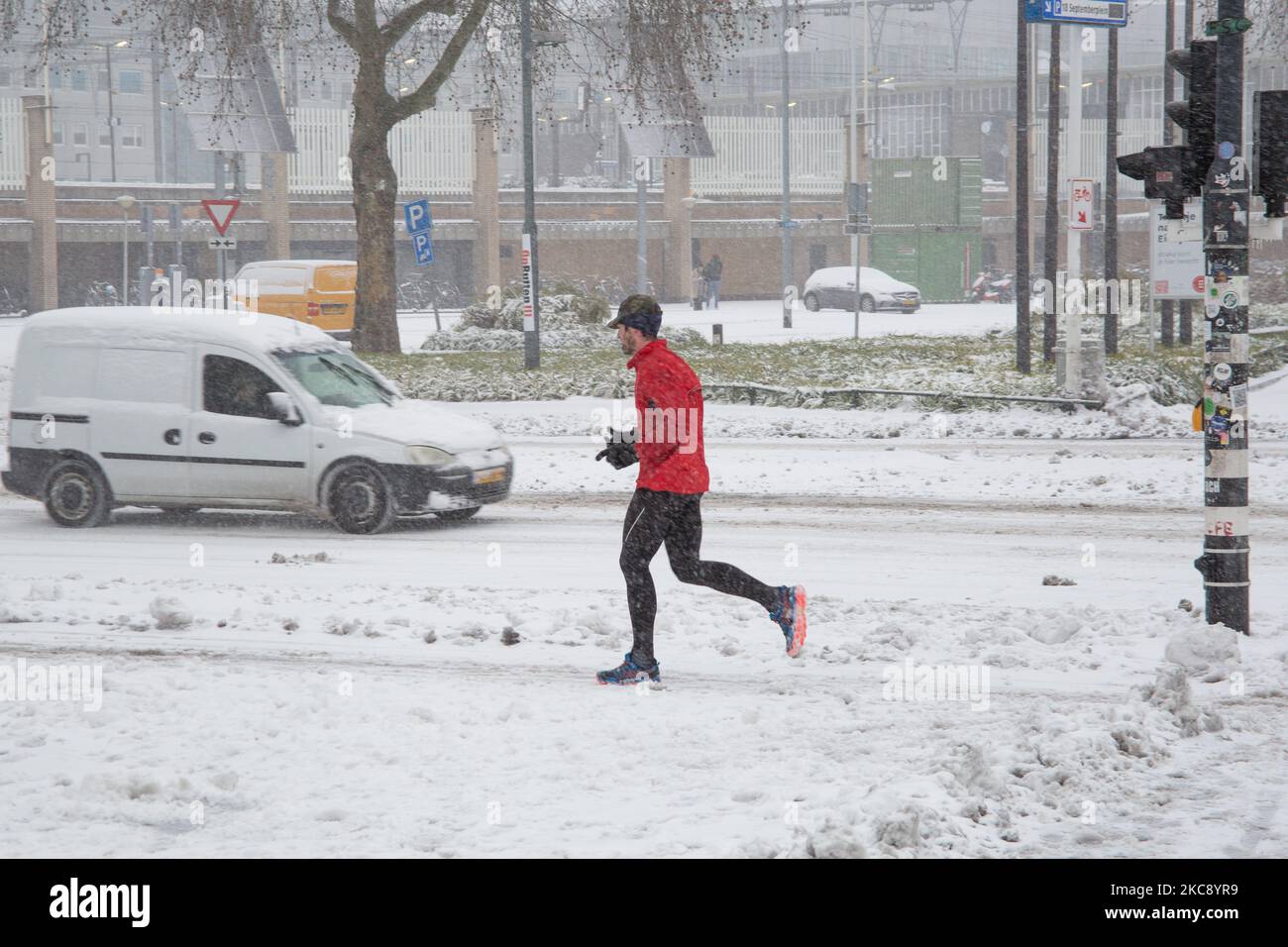 Ein Mann, der auf dem Schnee läuft. Blizzard vom Schneesturm Darcy in den Niederlanden, dem ersten starken Schneefall mit starken Winden nach 2010, der den Transport im ganzen Land störte. Die Niederländer erwachten am Sonntag mit einer Schneeschicht, die alles bedeckte. Viele Unfälle ereigneten sich auf den Straßen aufgrund des Sturms und der eisigen Bedingungen, während es auch Probleme mit den Zügen gab. In der Stadt Eindhoven in Nordbrabant wurde der Bahn- und Busverkehr eingestellt, der Flughafen folgte und der Luftverkehr umgeleitet. Die Leute gingen in die Innenstadt von Eindhoven, um die zu genießen und Spaß mit der zu haben Stockfoto