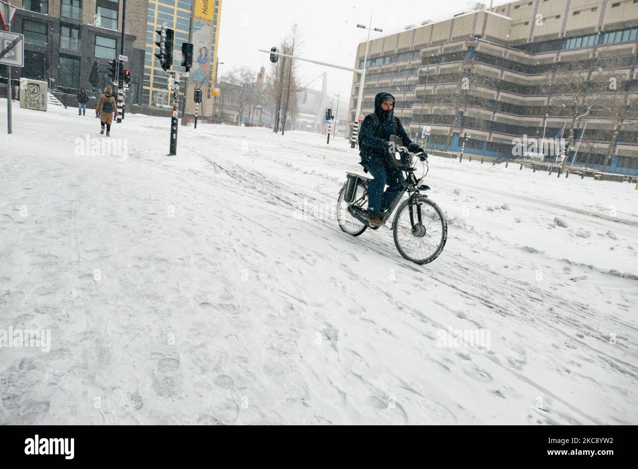 Im schneebedeckten Stadtzentrum von Eindhoven werden die Menschen am 18. Septemberplein mit ihrem Fahrrad auf dem Schnee fahren sehen. Blizzard vom Schneesturm Darcy in den Niederlanden, dem ersten starken Schneefall mit starken Winden nach 2010, der den Transport im ganzen Land störte. Die Niederländer erwachten am Sonntag mit einer Schneeschicht, die alles bedeckte. Viele Unfälle ereigneten sich auf den Straßen aufgrund des Sturms und der eisigen Bedingungen, während es auch Probleme mit den Zügen gab. In der Stadt Eindhoven in Nordbrabant wurde der Bahn- und Busverkehr eingestellt, der Flughafen folgte und der Luftverkehr umgeleitet Stockfoto