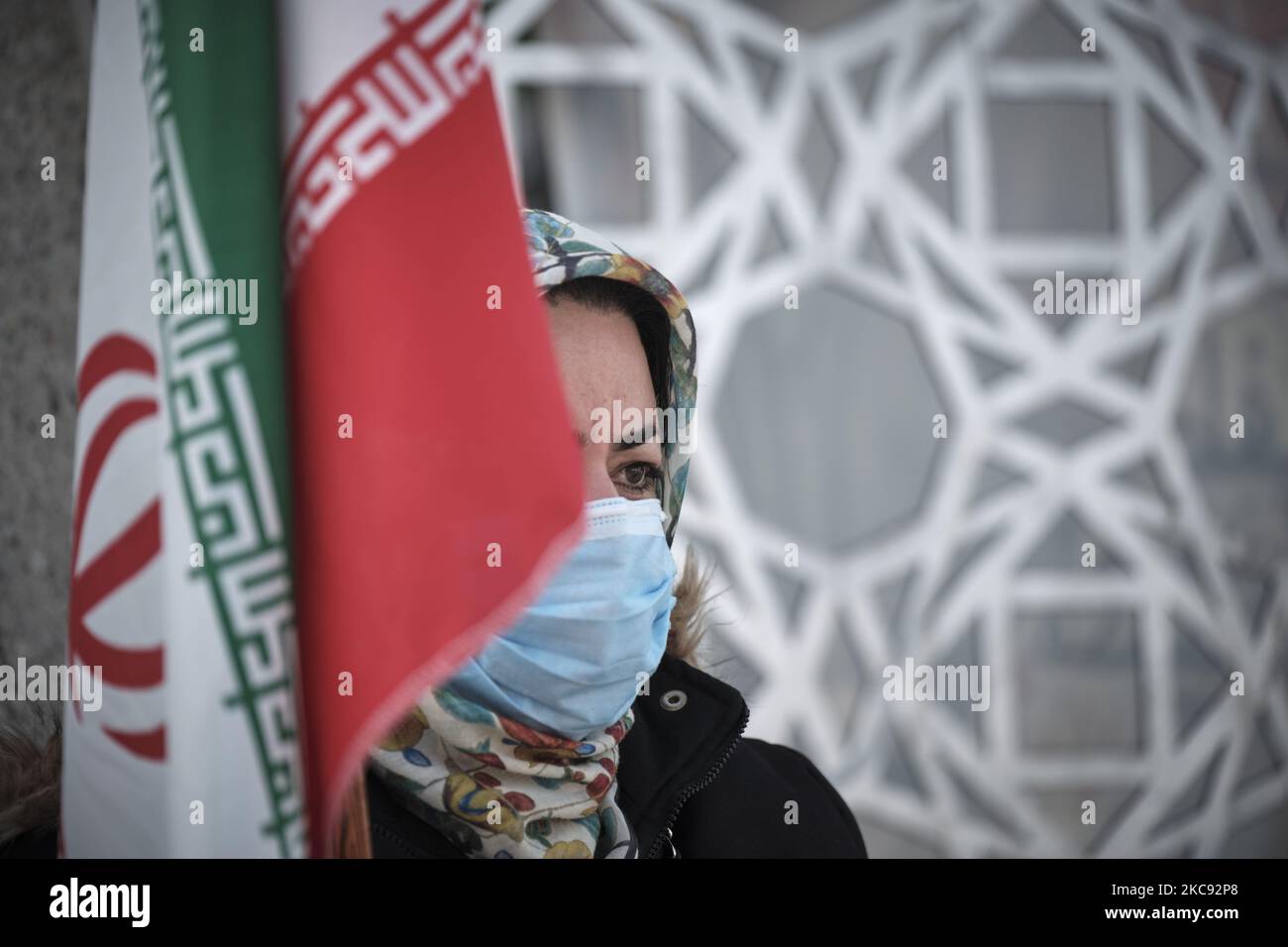 Eine iranische Frau mit einer schützenden Gesichtsmaske hält eine iranische Flagge, während sie an einer Kundgebung zum Gedenken an den 42.. Jahrestag des Sieges der Islamischen Revolution, die mit Motorrädern inmitten des Ausbruchs der neuen Coronavirus-Krankheit (COVID-19) im Iran am Imam Hussein Platz im Süden Teherans am 10. Februar 2021 stattfand, teilnahm. (Foto von Morteza Nikoubazl/NurPhoto) Stockfoto