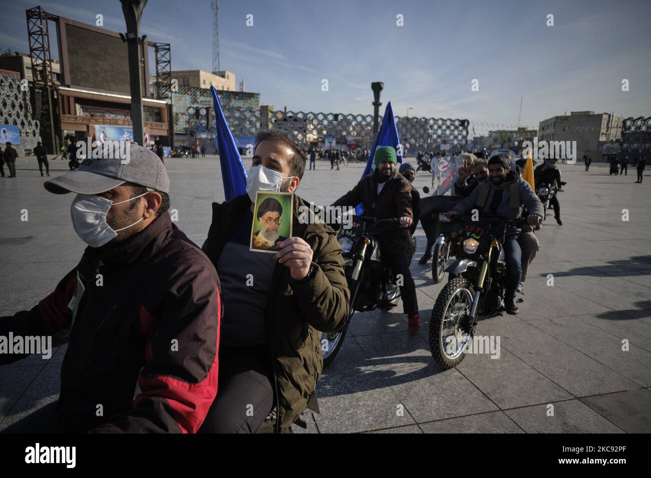 Ein iranischer Mann mit einer schützenden Gesichtsmaske hält ein Porträt des iranischen Obersten Führers Ayatollah Ali Khamenei, während er an einer Kundgebung zum Gedenken an den 42.. Jahrestag des Sieges der Islamischen Revolution teilnimmt. Das fand am 10. Februar 2021 auf dem Imam Hussein-Platz im Süden Teherans mit Motorrädern statt, als die neue Coronavirus-Krankheit (COVID-19) im Iran ausbrach. (Foto von Morteza Nikoubazl/NurPhoto) Stockfoto