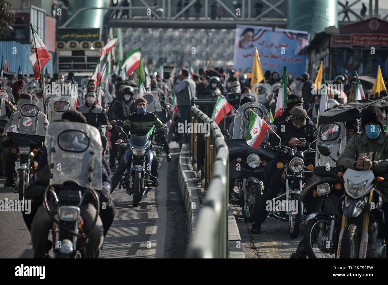 Iranische Motorradfahrer, die iranische Flaggen tragen, fahren auf der Enghelab-Straße (Revolution) entlang, während einer Kundgebung zum Gedenken an den 42.. Jahrestag des Sieges der Islamischen Revolution, die am 10. Februar 2021 mit Motorrädern inmitten des Ausbruchs der neuen Coronavirus-Krankheit (COVID-19) im Iran im Süden Teherans stattfand. (Foto von Morteza Nikoubazl/NurPhoto) Stockfoto