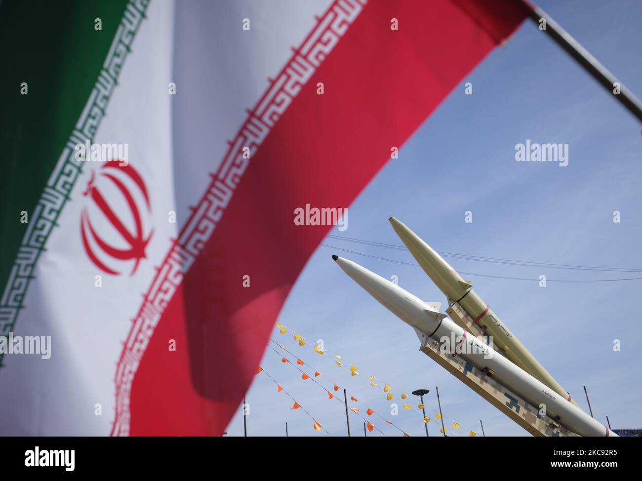 Auf dem Azadi (Freedom)-Platz werden im Rahmen einer Kundgebung zum Gedenken an den 42.. Jahrestag des Sieges der Islamischen Revolution neben einer iranischen Flagge fahrende einstufige, mit Festantrieb betriebene, flüssigkeitsbetriebene Raketen der Dezful Mittelstreckenrakete (unten) und Zolfaghar-Straßenmobile gesehen. Das fand am 10. Februar 2021, am 10. Februar 2021, in Teheran mit Motorrädern unter dem Ausbruch der neuen Coronavirus-Krankheit (COVID-19) im Iran statt. (Foto von Morteza Nikoubazl/NurPhoto) Stockfoto