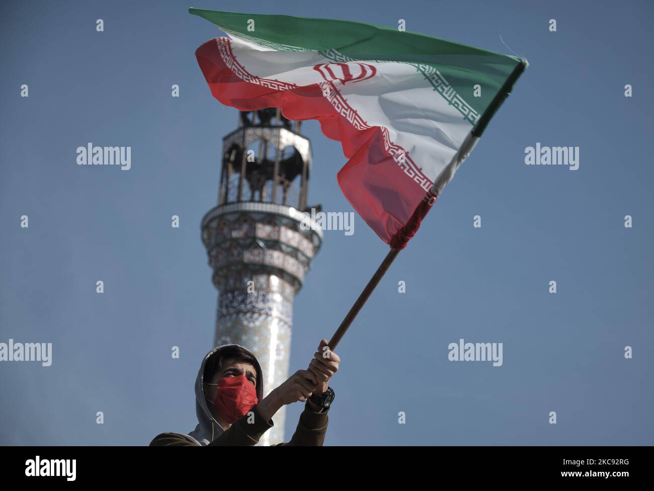 Ein iranischer Mann mit einer schützenden Gesichtsmaske schwingt eine iranische Flagge, während er an einer Kundgebung zum Gedenken an den 42.. Jahrestag des Sieges der Islamischen Revolution teilnimmt, Die am 10. Februar 2021, am 10. Februar 2021, auf dem Imam Hussein Platz im Süden Teherans, mit Motorrädern während des Ausbruchs der neuen Coronavirus-Krankheit (COVID-19) im Iran stattfand. (Foto von Morteza Nikoubazl/NurPhoto) Stockfoto