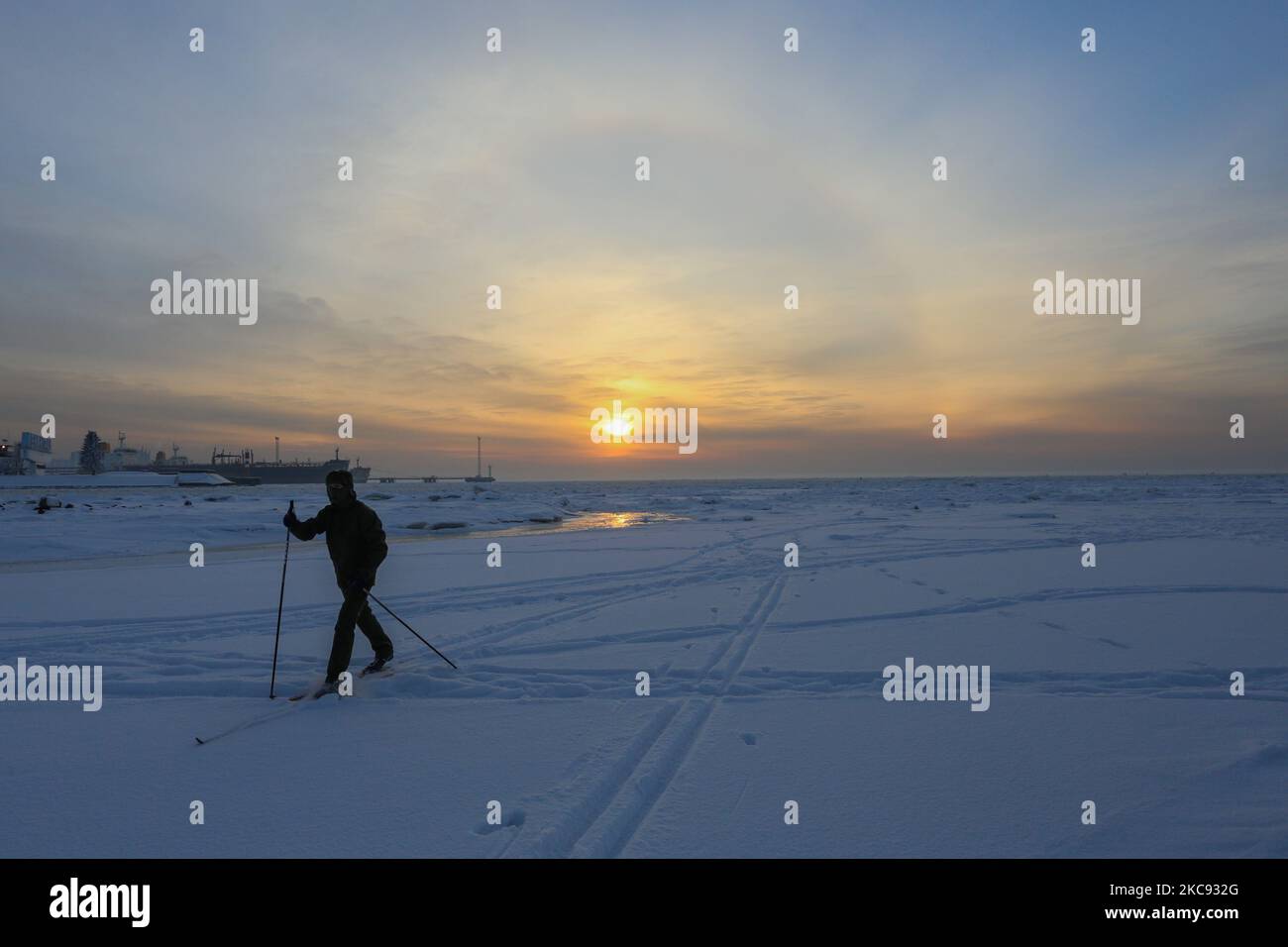 Am 10. Februar 2021 fährt ein Mann auf dem Eis des Finnischen Meerbusens während eines Halos an einem frostigen Tag in Sankt Petersburg, Russland. Die Temperatur in St. Petersburg sank auf -16 Grad. (Foto: Valya Egorshin/NurPhoto) Stockfoto