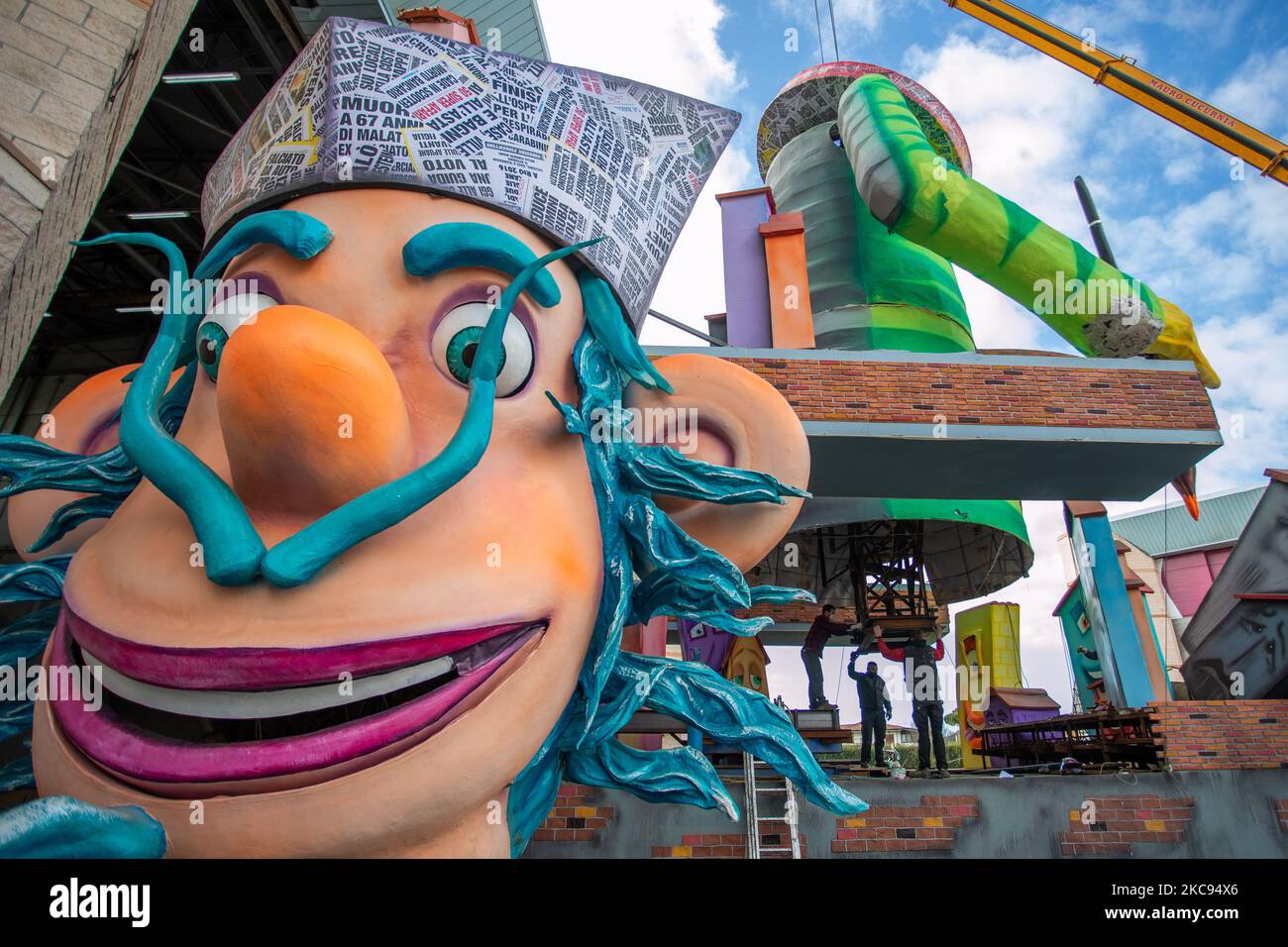 Menschen arbeiten auf dem Platz von Cittadella vor dem Lagerhaus, wo die allegorischen Schwimmer 