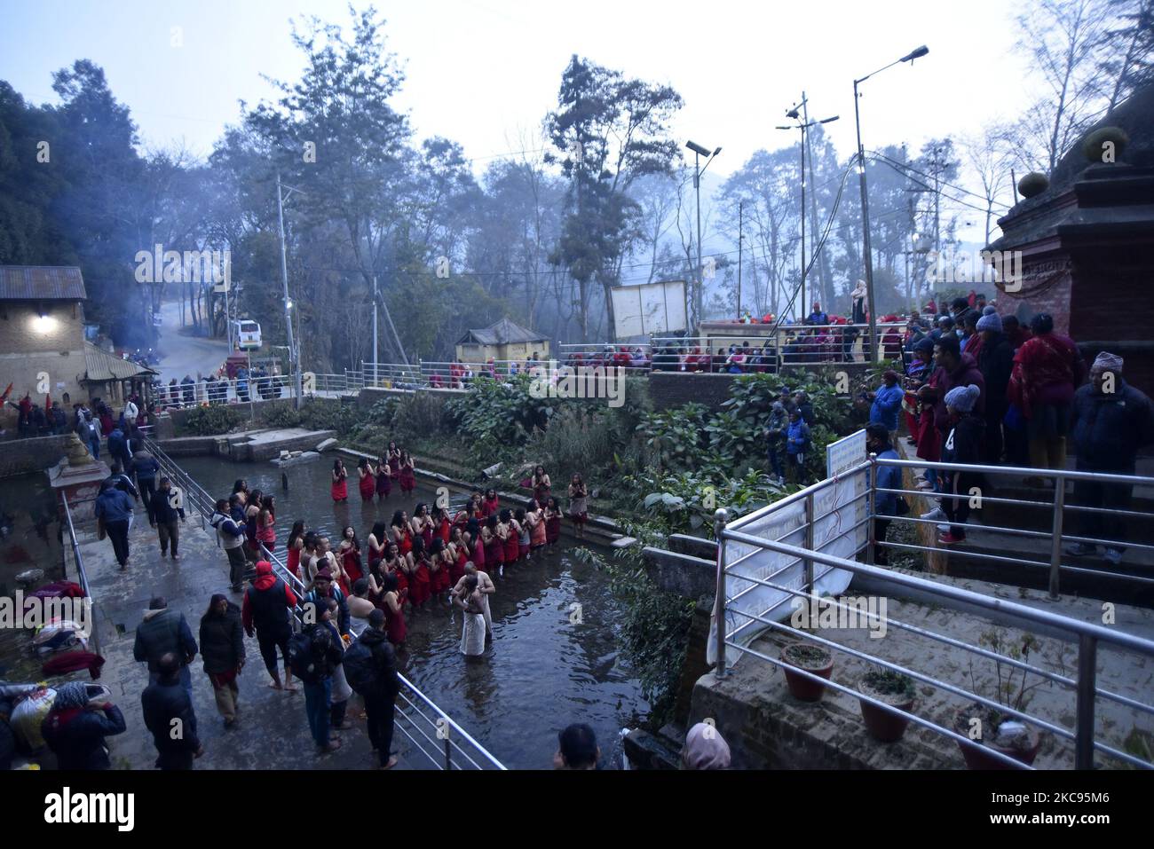 Nepalesische Hindu-Anhänger, die sich während des Madhav Narayan Festivals anstellen, um Weihwasser aus dem Pharping Pond zu holen, oder Swasthani Brata Katha in Pharping, Kathmandu, Temple, Kathmandu, Nepal am Freitag, 12. Februar 2021. Nepalesische Hindu-Frauen beobachten ein Fasten und beten zur Göttin Swasthani für ein langes Leben ihrer Ehemänner und den Wohlstand ihrer Familie während einer einmonatigen Fastenfestfeier. Der Ausschuss von Salinadi Mela hat aufgrund der COVID-19-Pandemie für dieses Jahr maximal 50 Anhänger festgesetzt. (Foto von Narayan Maharjan/NurPhoto) Stockfoto